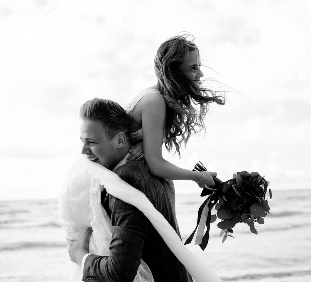 A series of connected black and white photos showing a couple embracing and dancing casually on the beach.