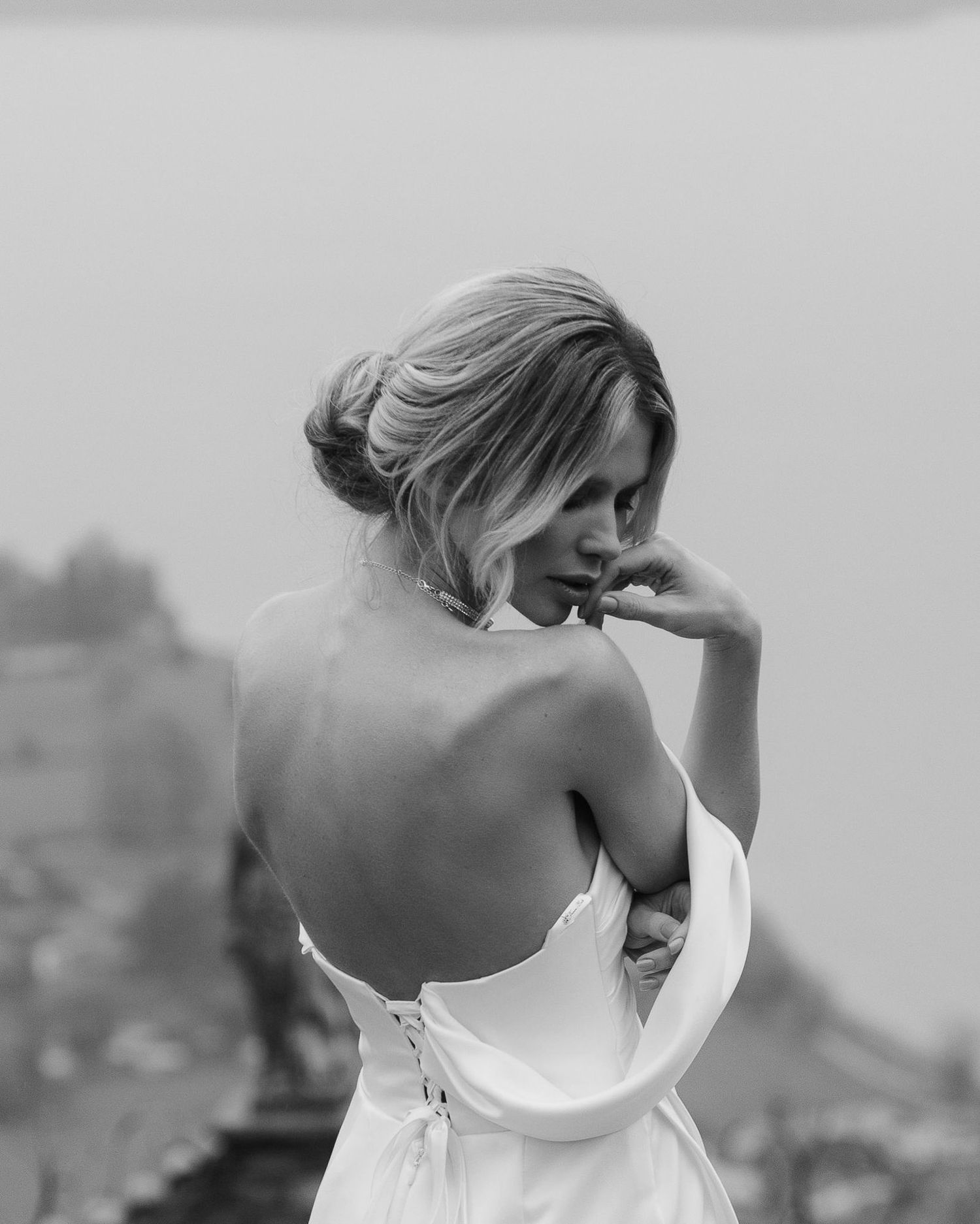 A black and white artistic photo series showing the same person in different poses with a crescent moon shape overlay.