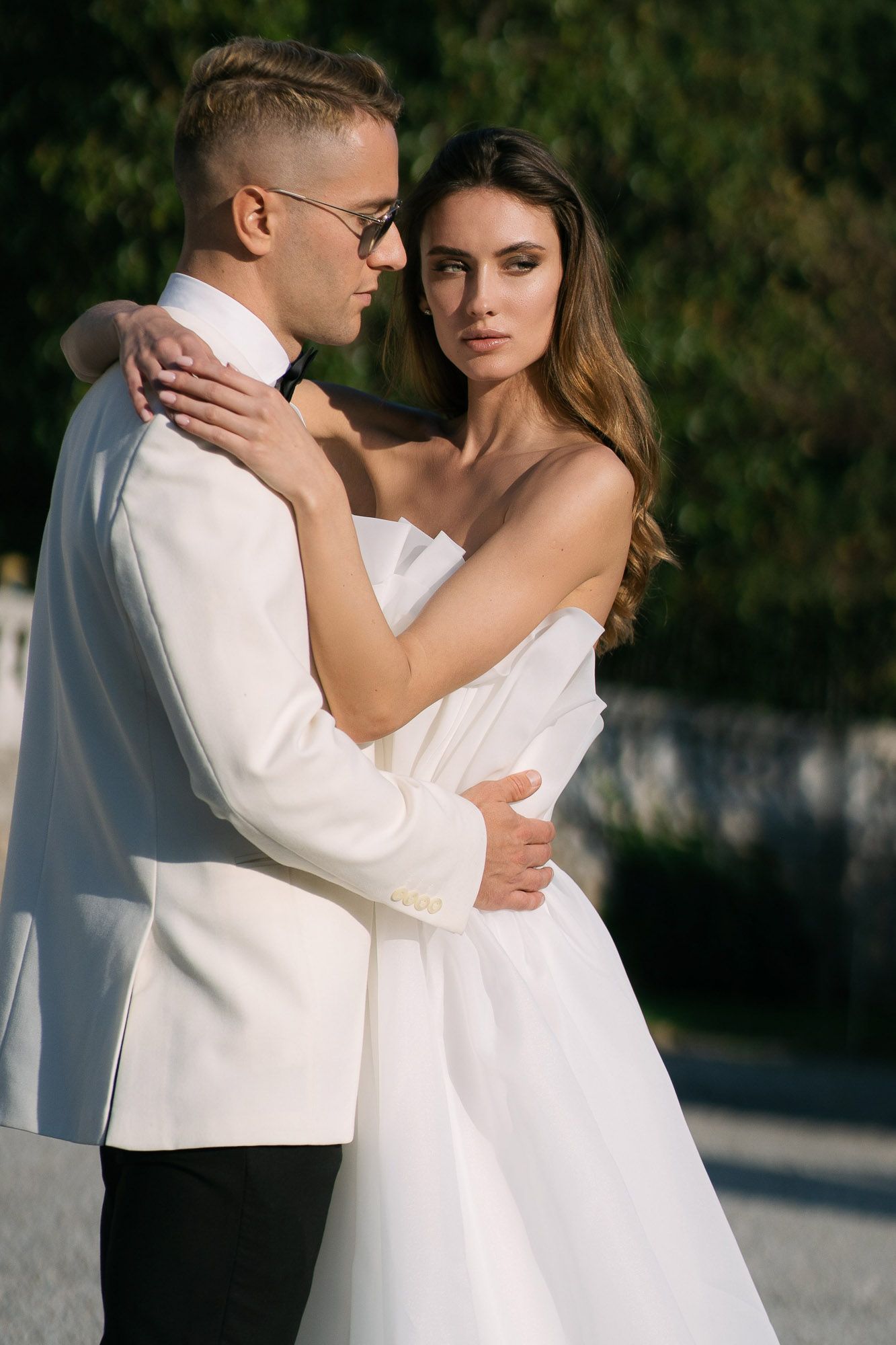 Romantic wedding portraits in white attire against a dark background creating an intimate atmosphere.