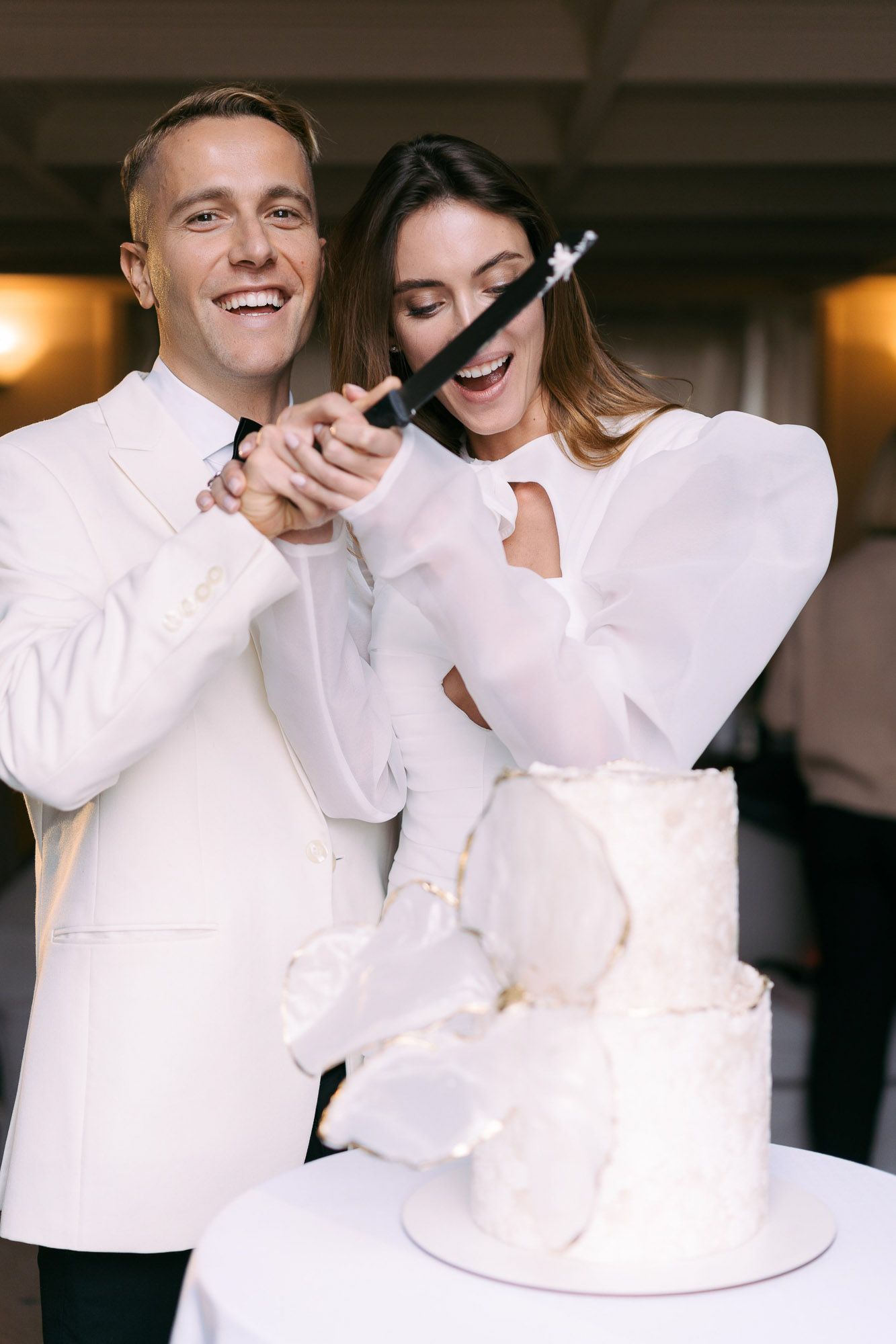 A couple in white outfits share joyful laughter and embraces in a series of candid moments.