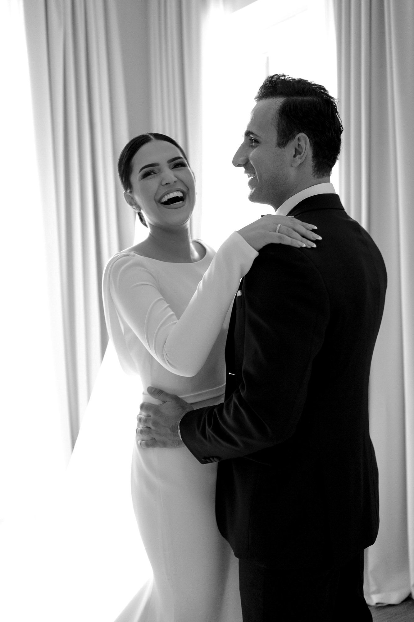 A couple in wedding attire shares a joyful moment together in front of white curtains, shown in a triptych sequence.