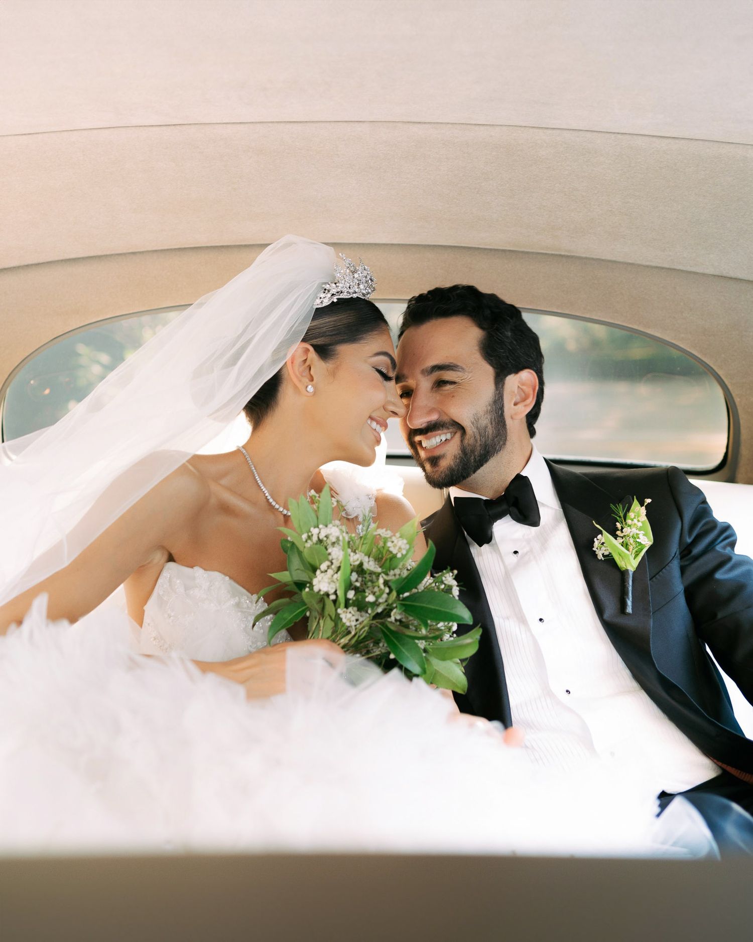 A romantic wedding couple shares intimate moments inside a vintage car during their wedding photo session.