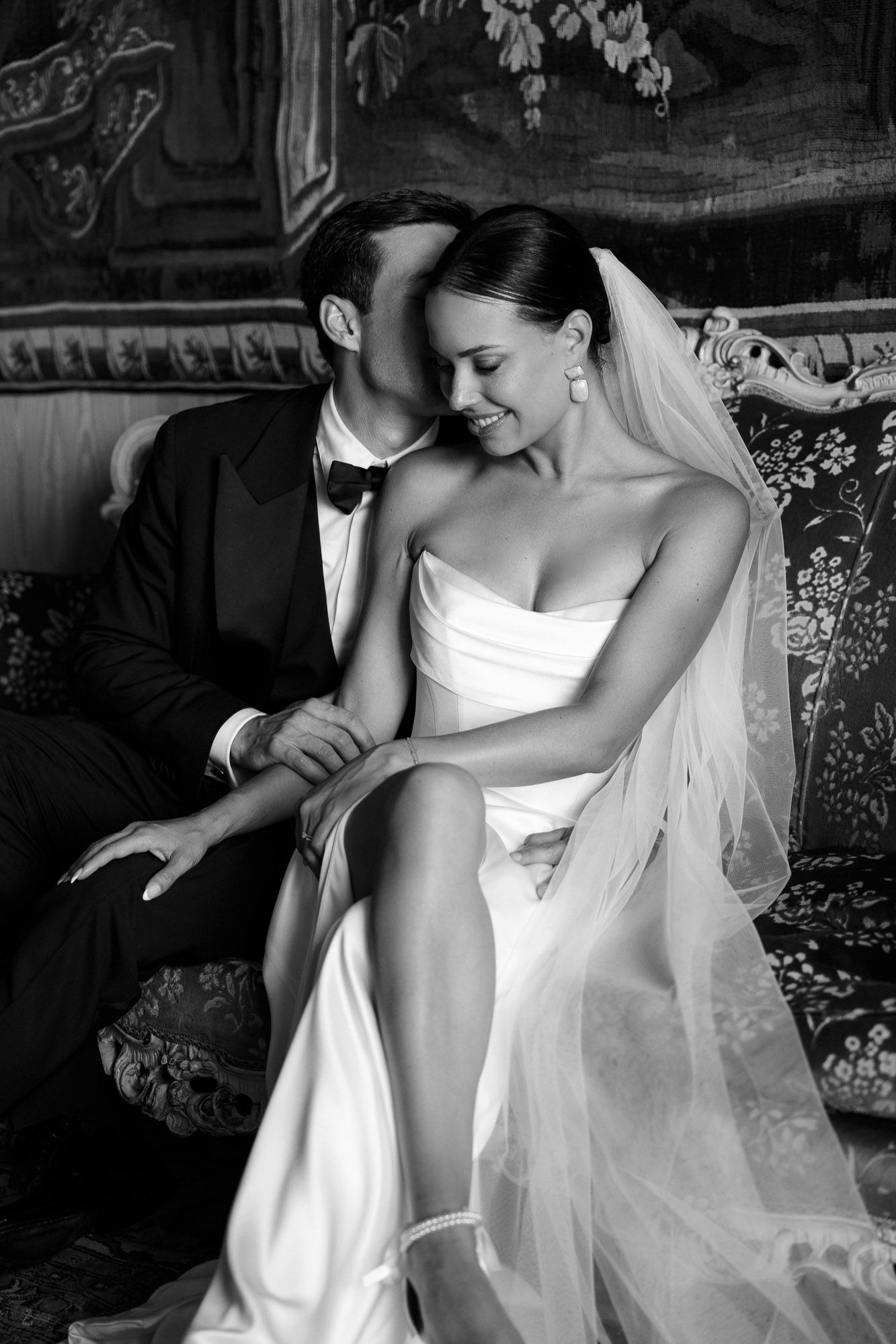 A series of black and white photos showing a bride in a white wedding dress and veil in various elegant poses.