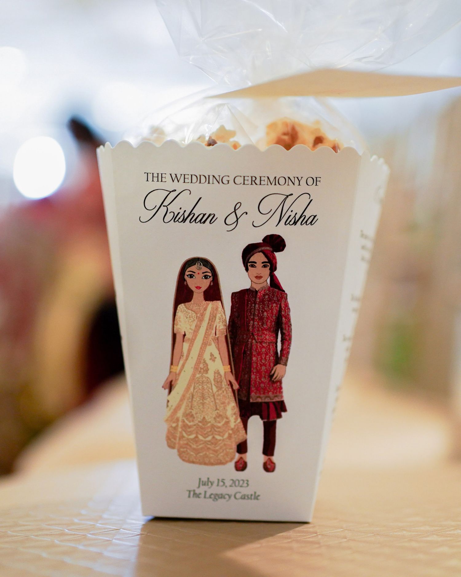 Wedding favor boxes featuring illustrated Indian bride and groom artwork displayed in a row on a white surface.