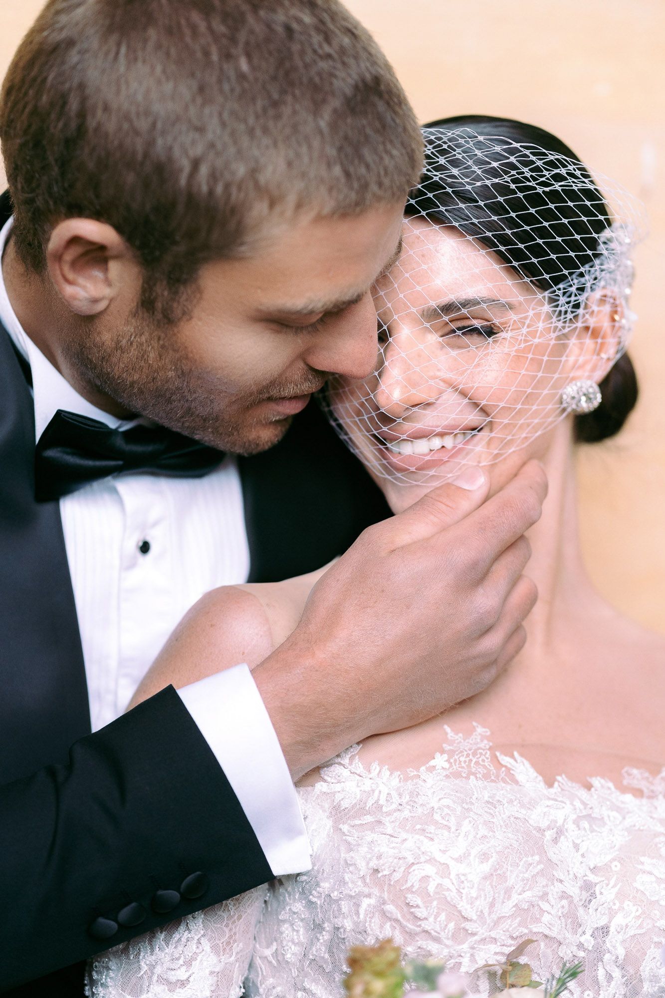 Intimate wedding portrait showing tender moments between newlyweds in classic black and white attire.