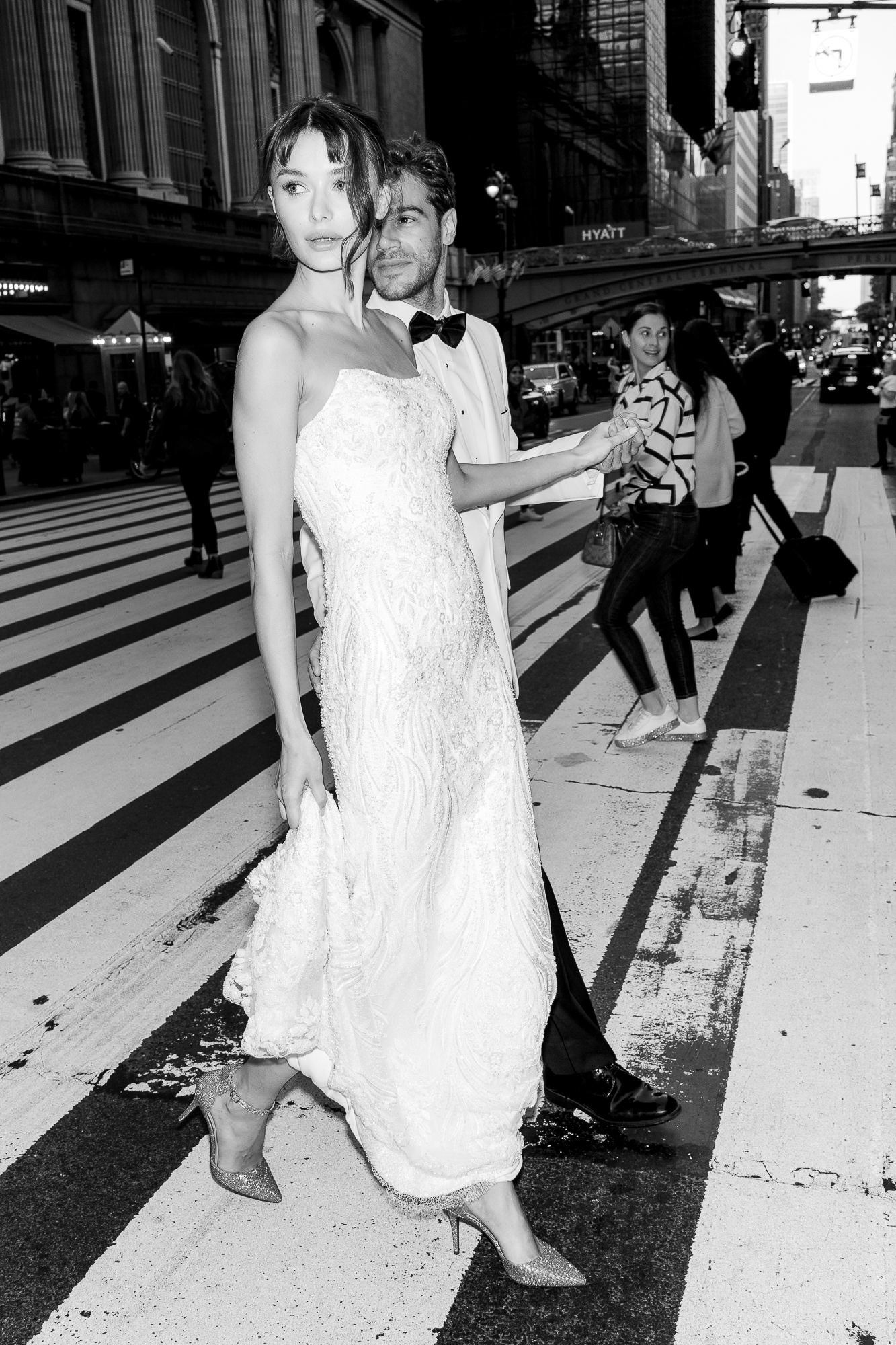 A sequence of black and white street photos showing a woman in a white dress walking on a city sidewalk.