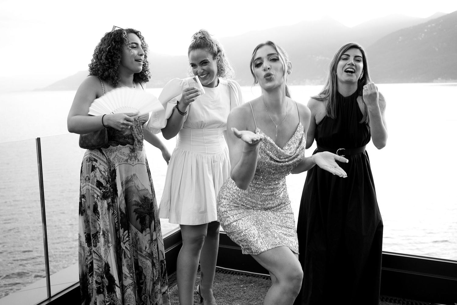 A group of people laughing and enjoying themselves on a beach at sunset.