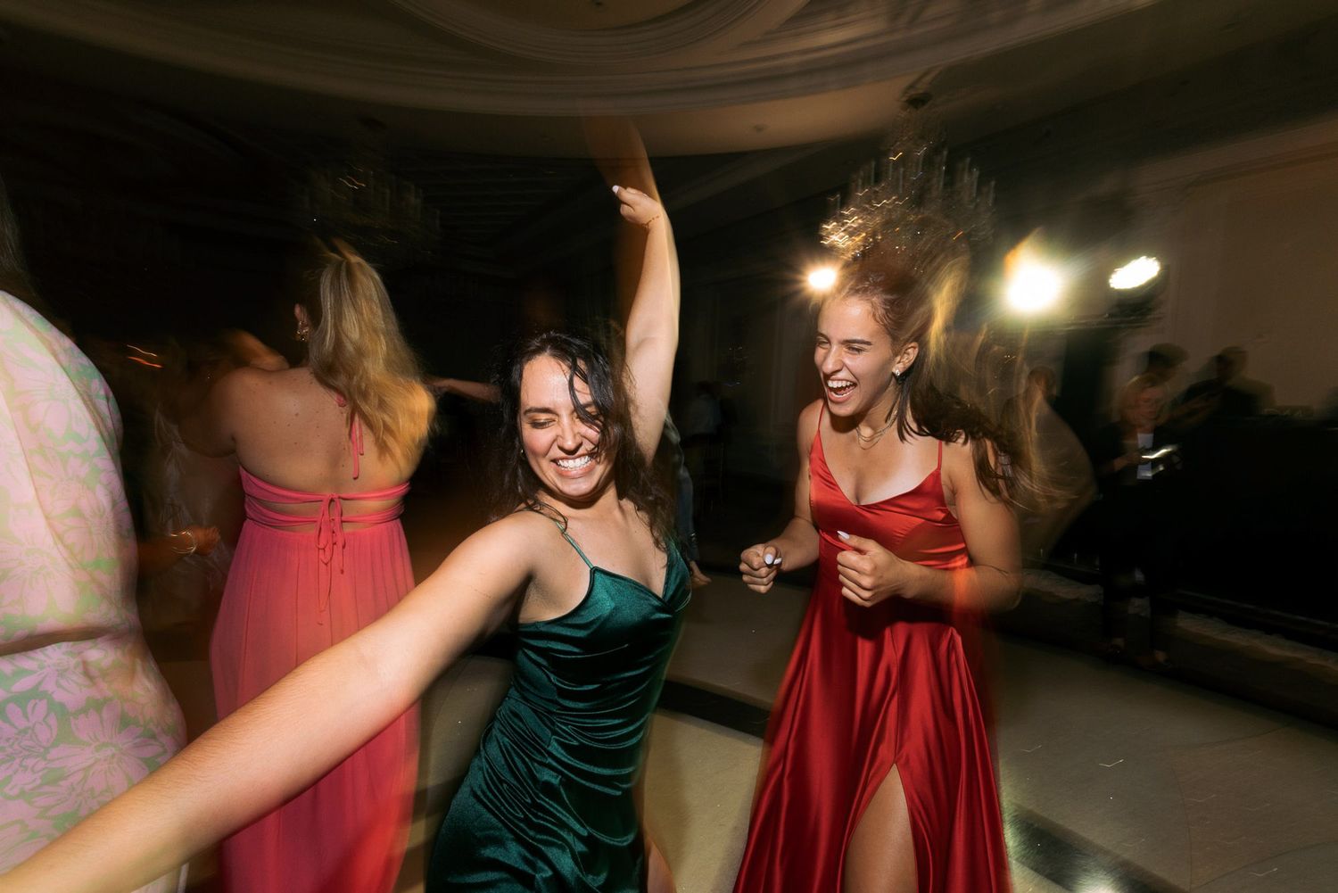 People dancing and celebrating at a dimly lit party or reception venue.