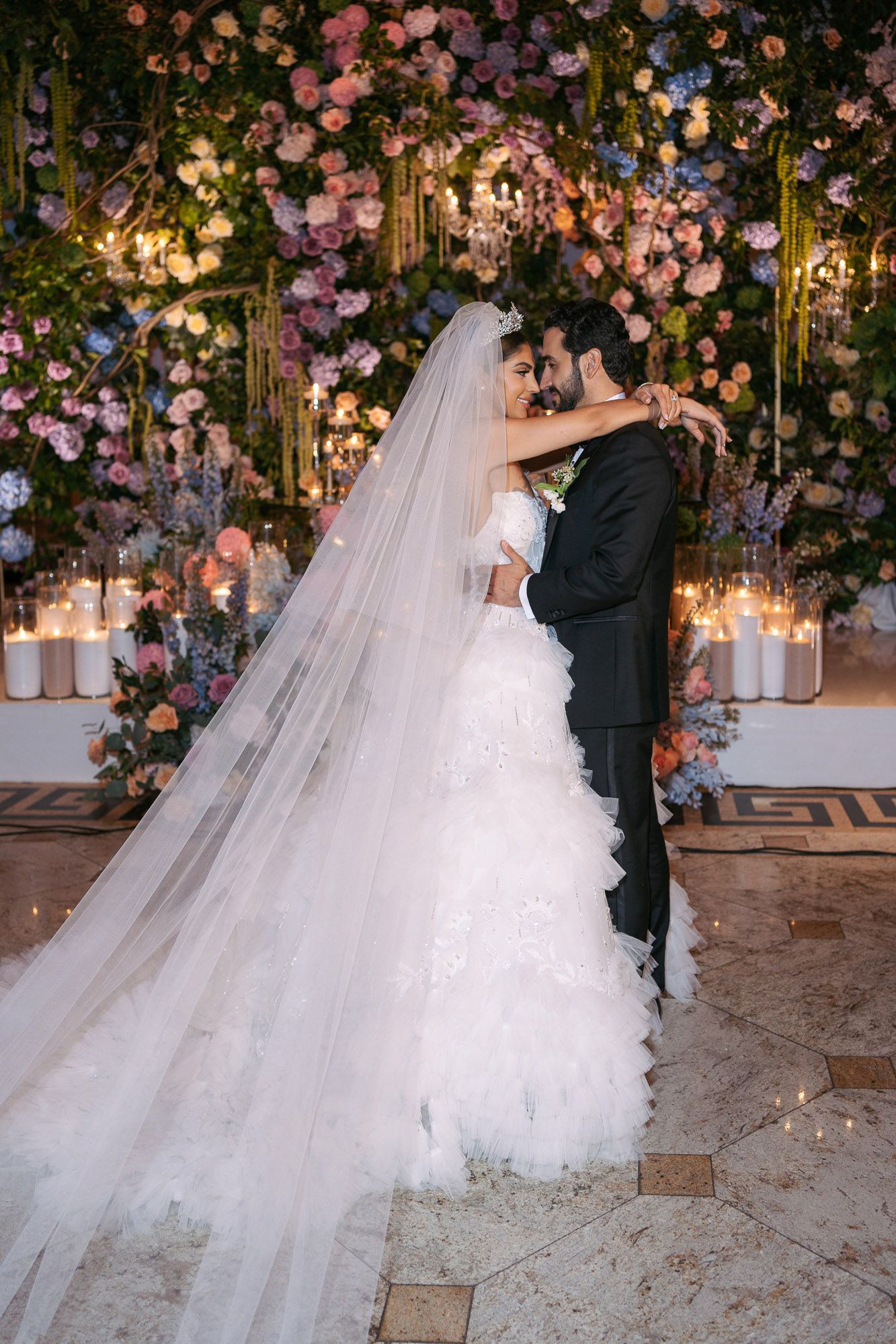 A romantic wedding scene with a floral arch adorned with pink roses and glowing lanterns creating a magical atmosphere.
