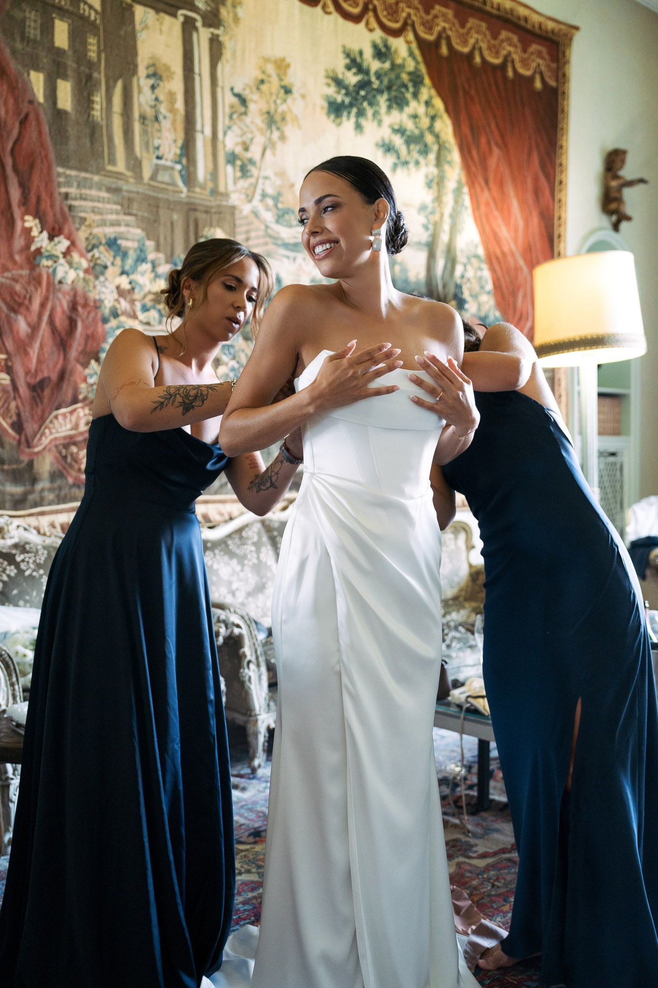 A sequence of four photos showing people in navy blue and white formal attire helping with wedding preparations.