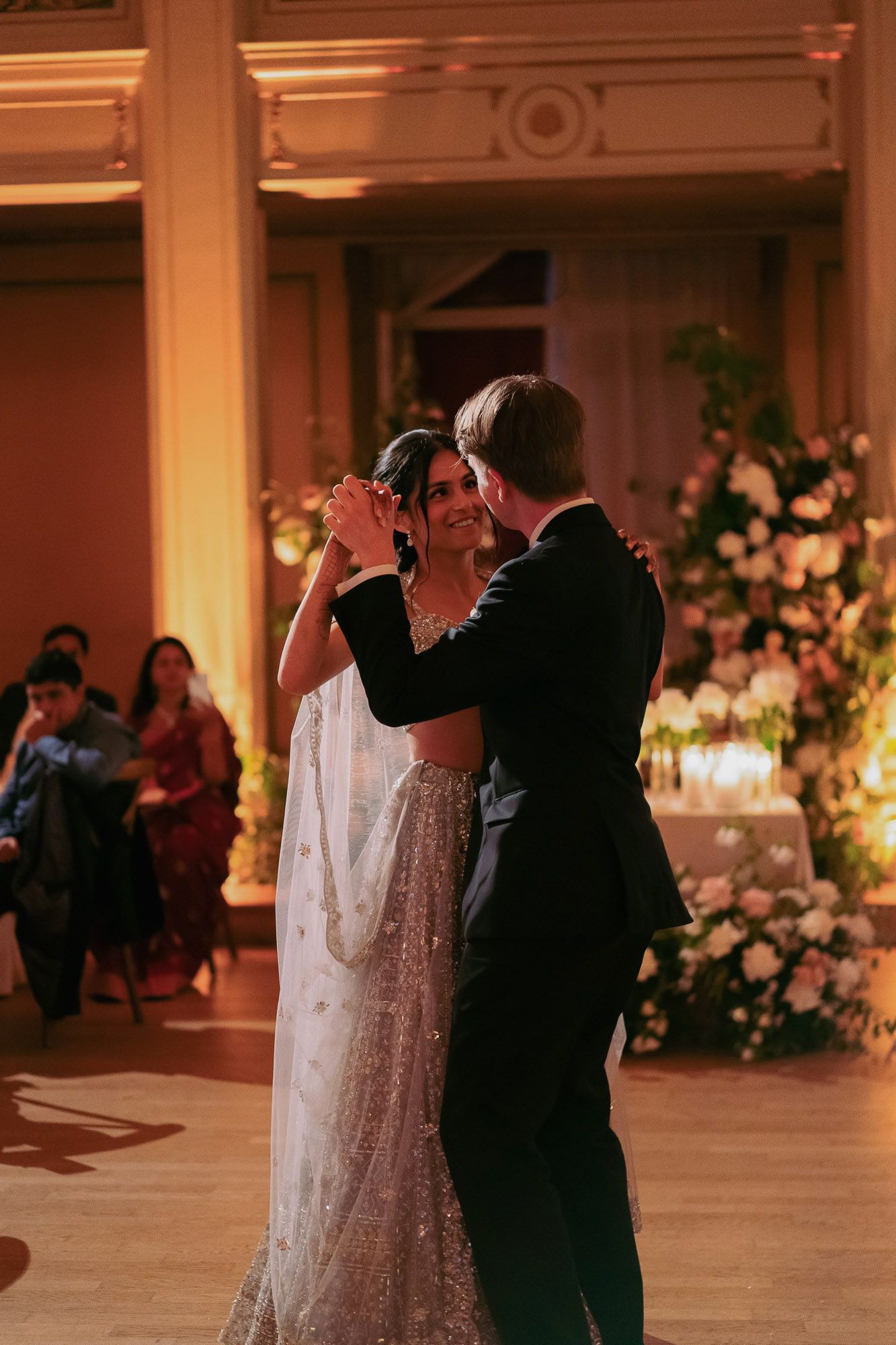 A series of dance moments captured at an elegant ballroom wedding reception with floral decorations.