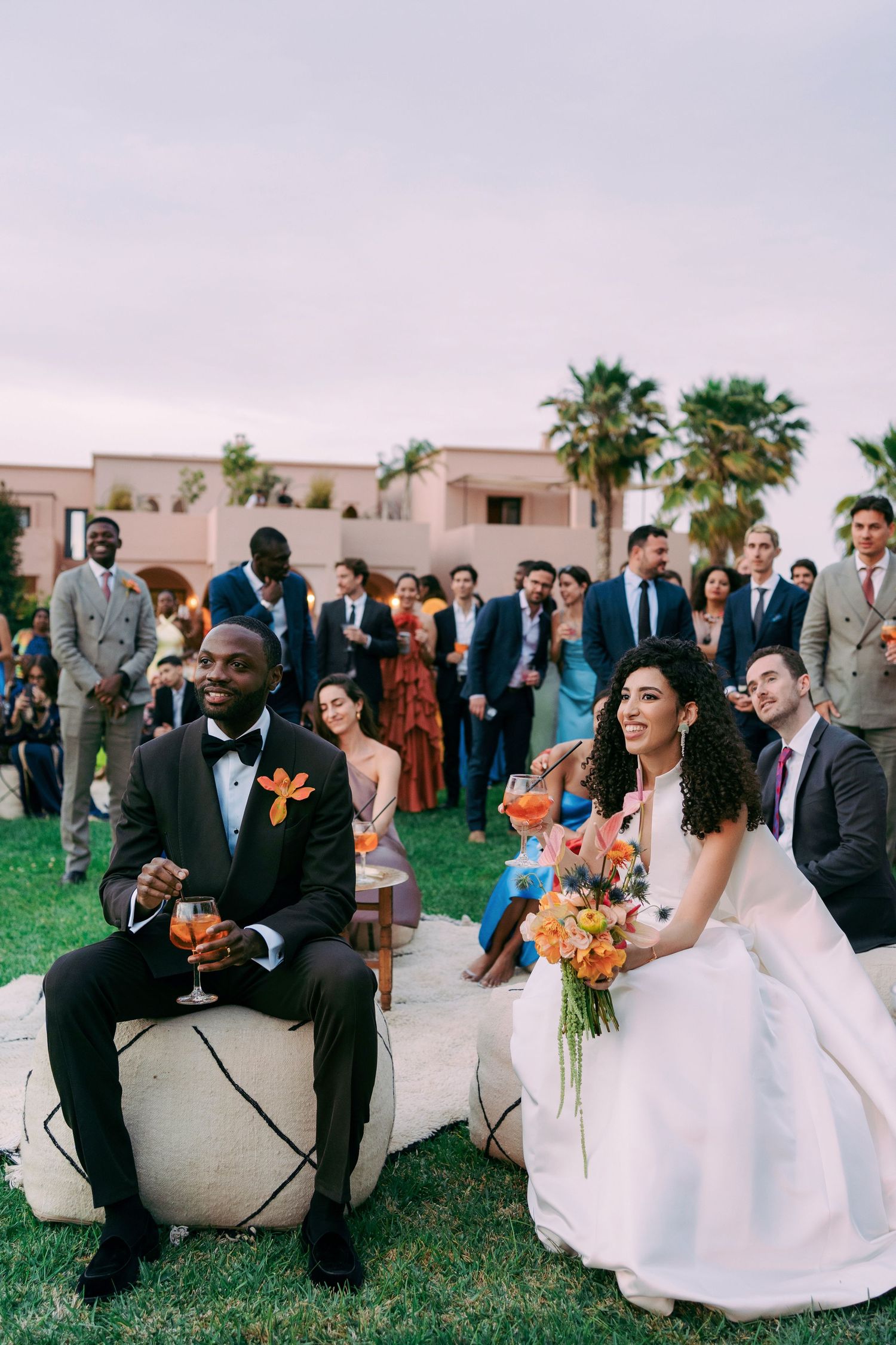 Wedding celebration with guests gathered around pool area at outdoor venue.