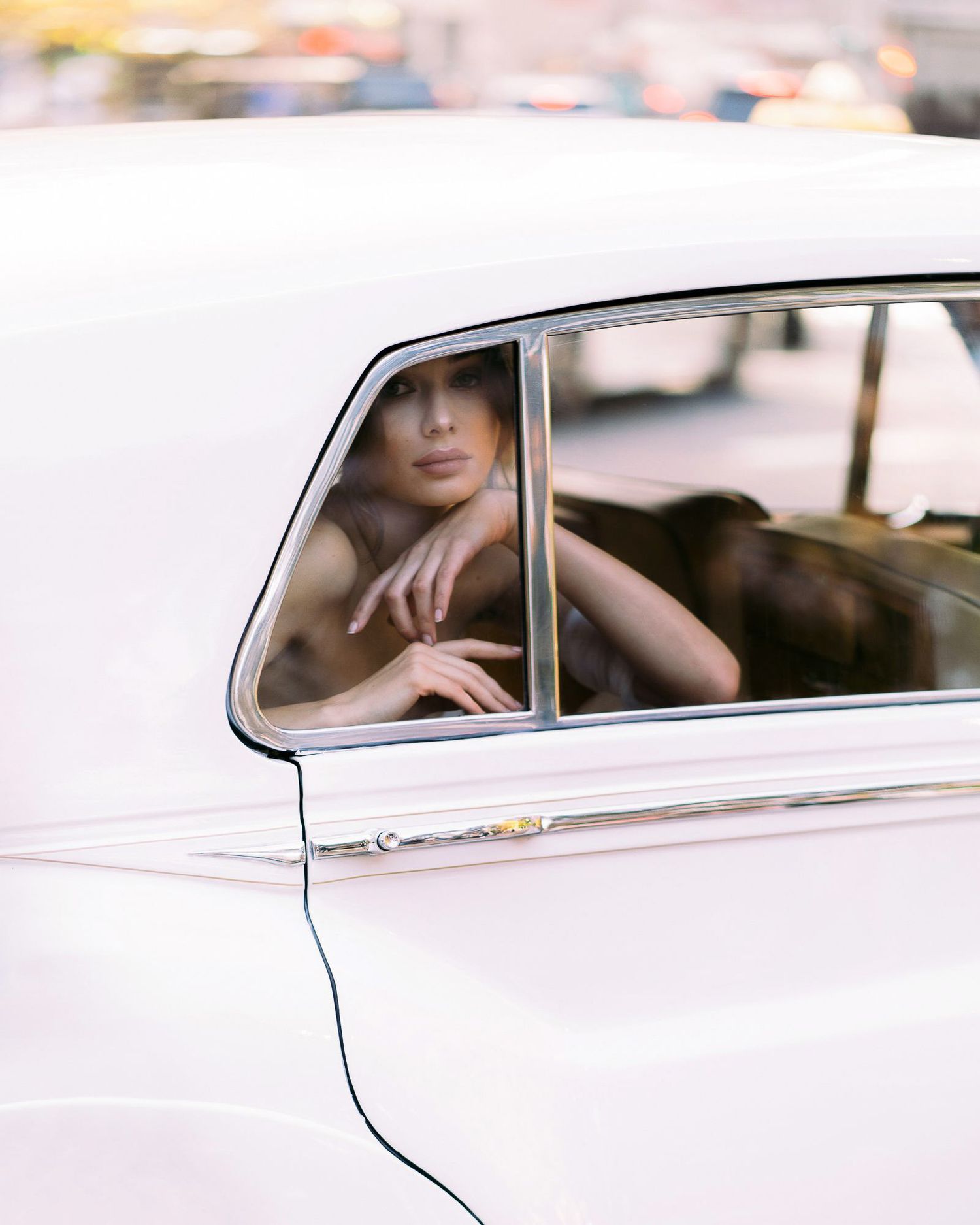 A classic white vintage car with elegant chrome details is photographed in soft natural lighting.
