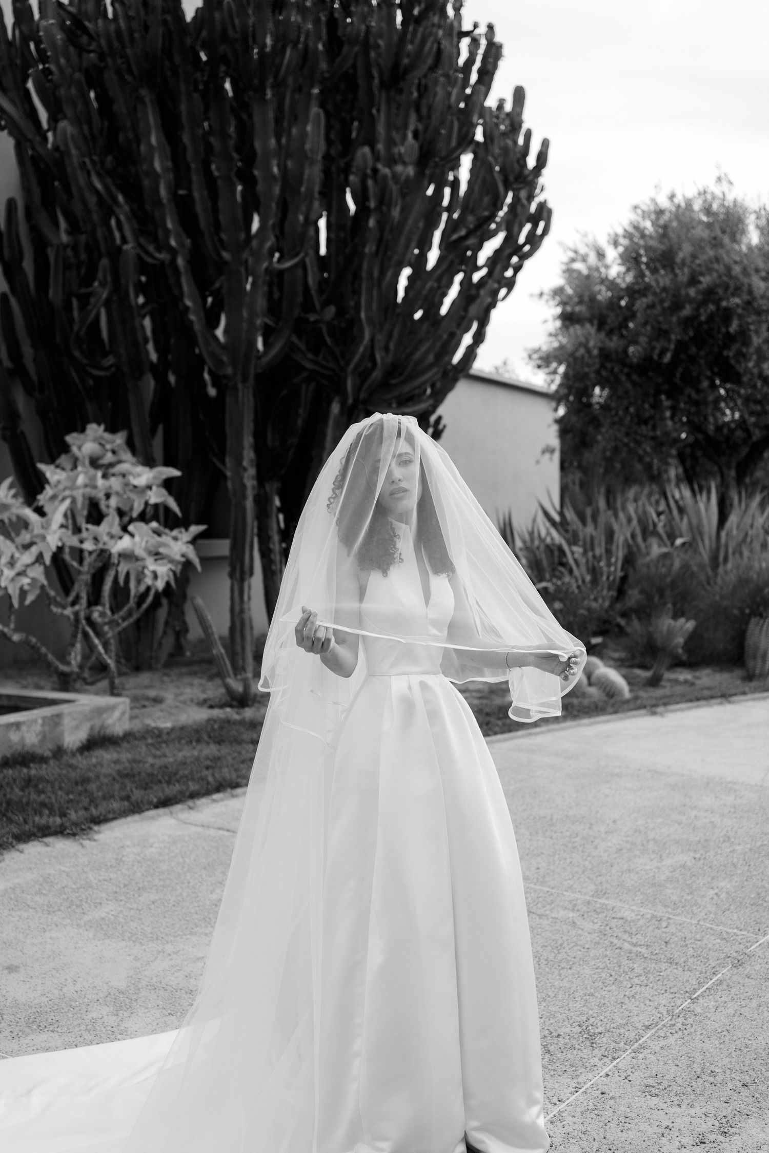Black and white photo series of flowing white wedding dress against desert landscape.