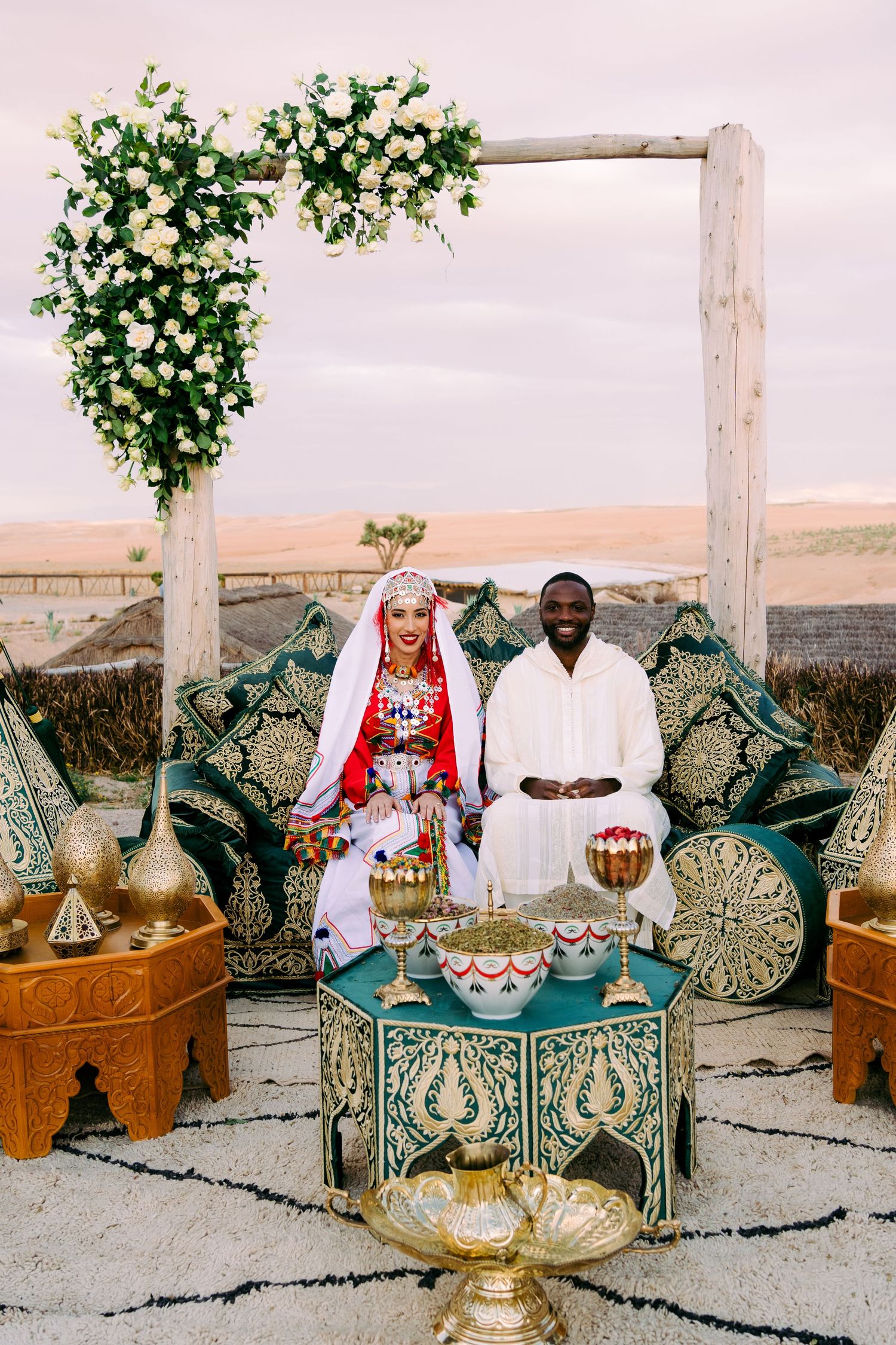 Traditional Moroccan seating area with ornate cushions and decorative tea service on wooden platforms.