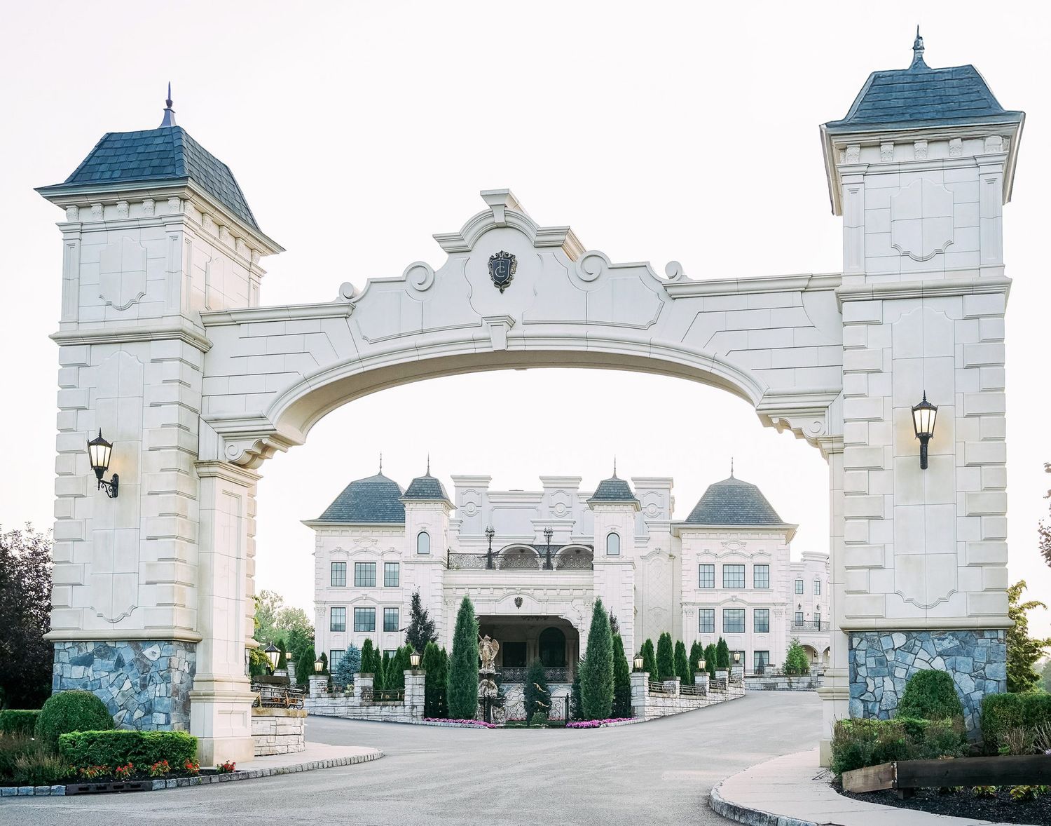 Elegant white wedding venue with ornate architectural details and domed towers set against a bright sky.