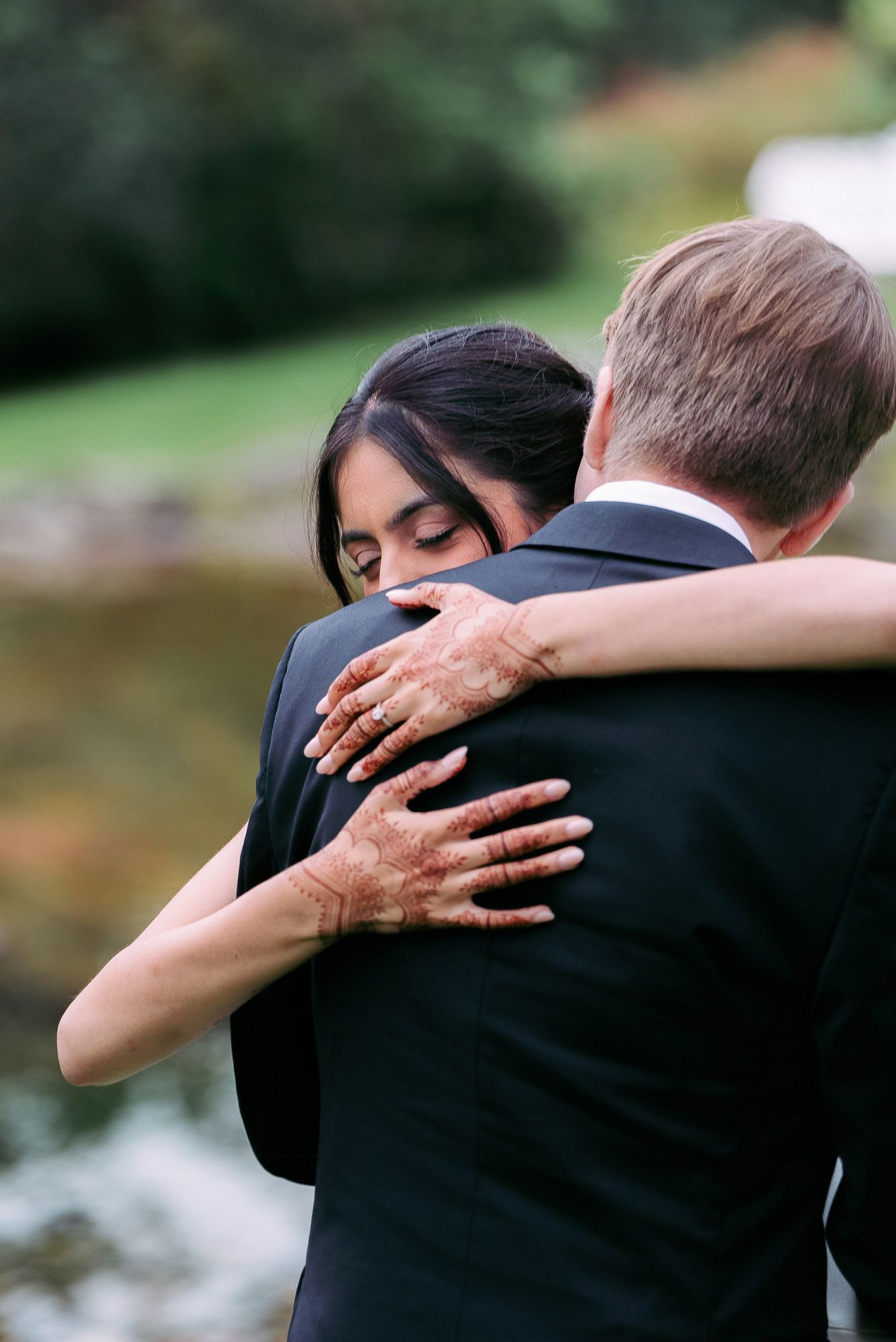 A romantic embrace captured in a series of intimate black and white photos by a lake.