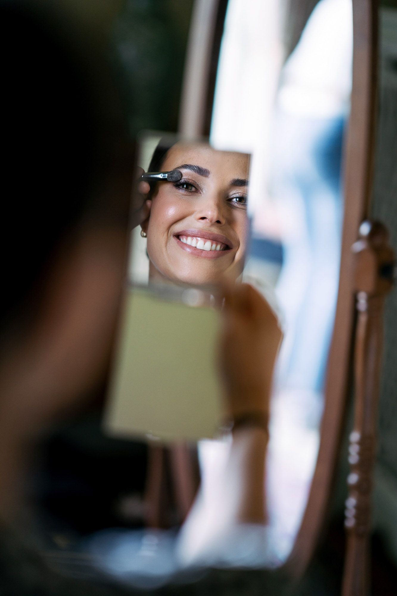 A series of blurred mirror reflections showing fragments of a smiling person in a soft, artistic composition.