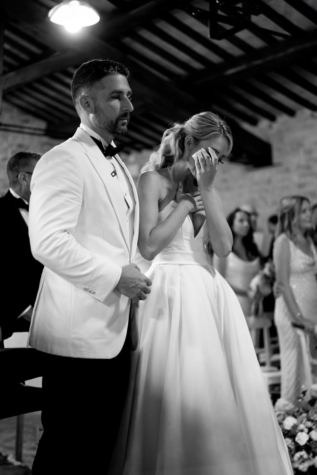 A couple shares a romantic first dance moment at their wedding reception in a rustic venue.