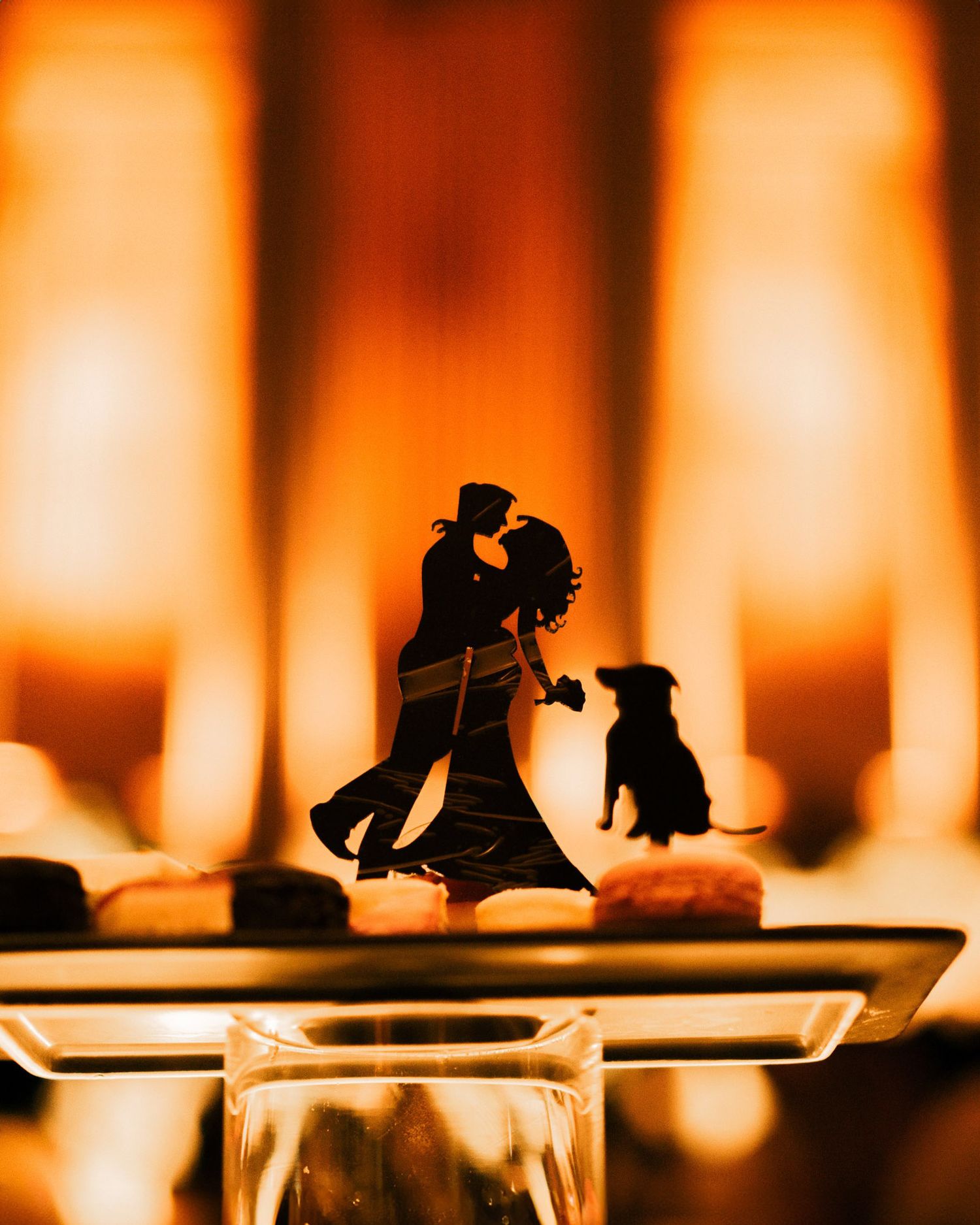 Silhouettes of dancers performing against an orange glowing background with a dramatic lighting effect.