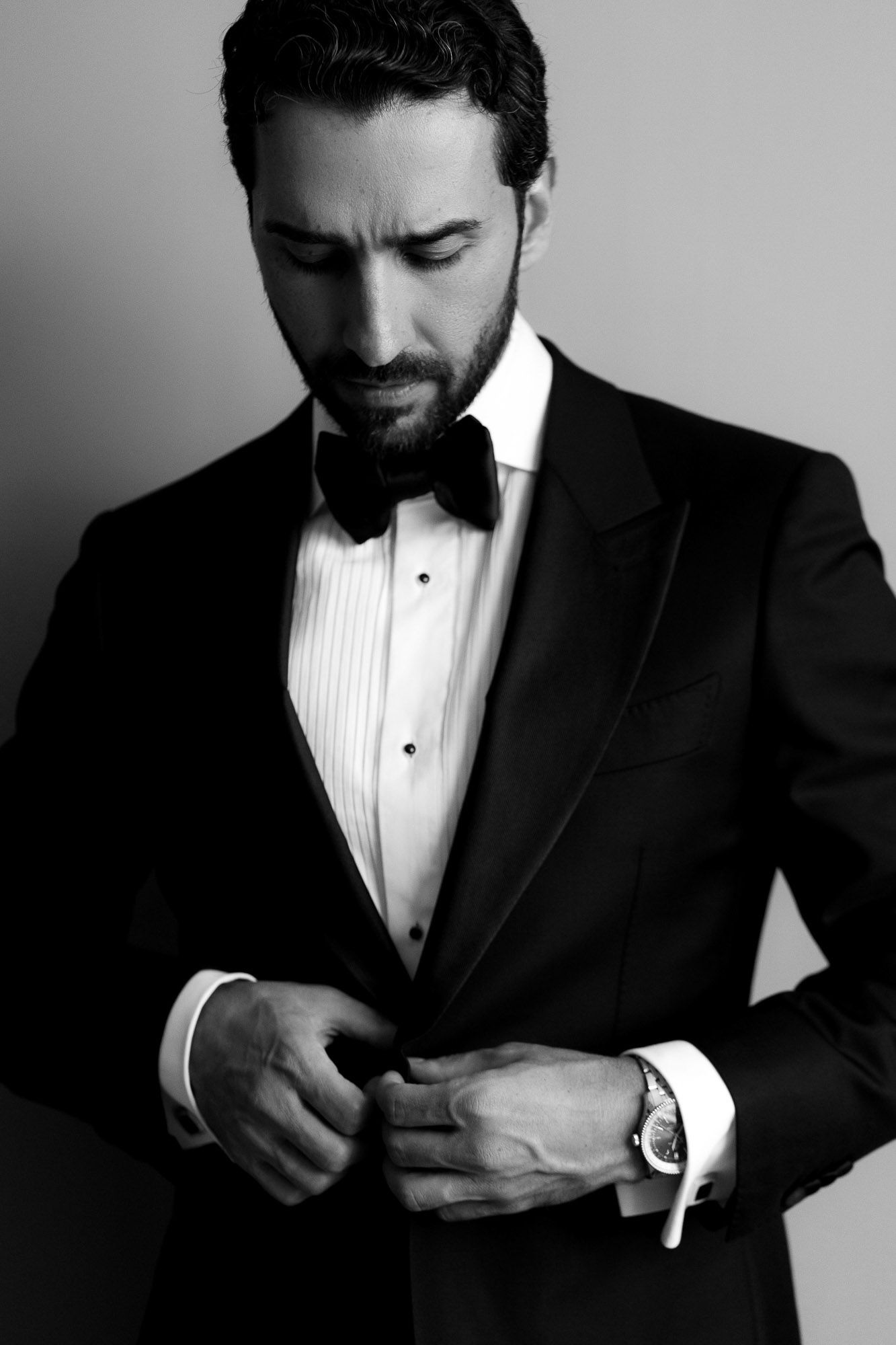 Black and white photo sequence of a person in a tuxedo adjusting their pocket square.