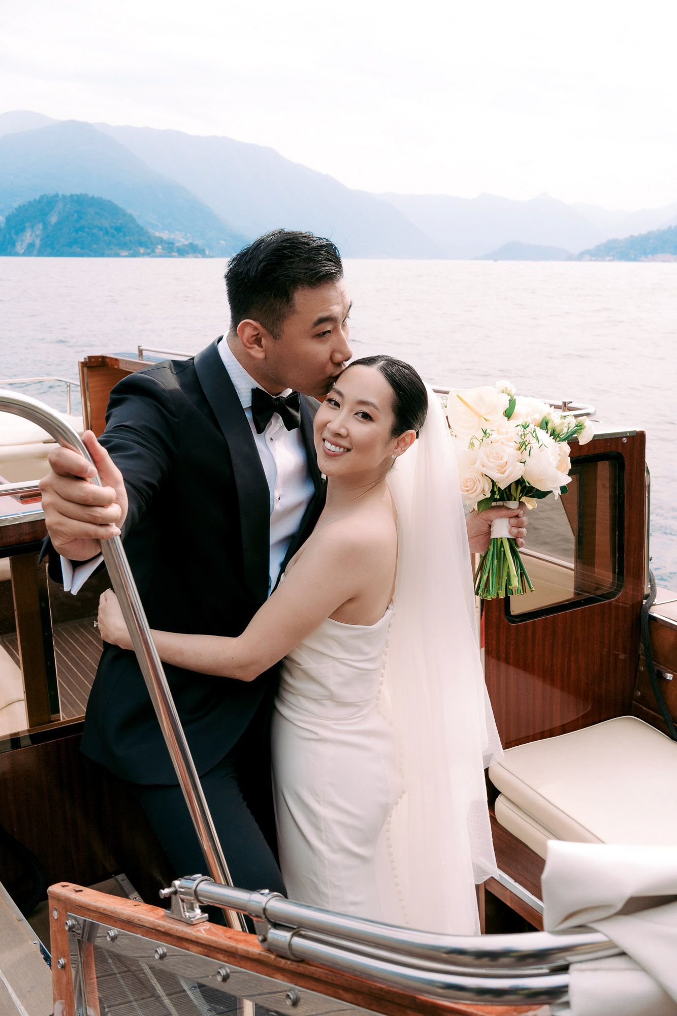 A romantic wedding couple sharing intimate moments while riding in a gondola with scenic mountain views in the background.