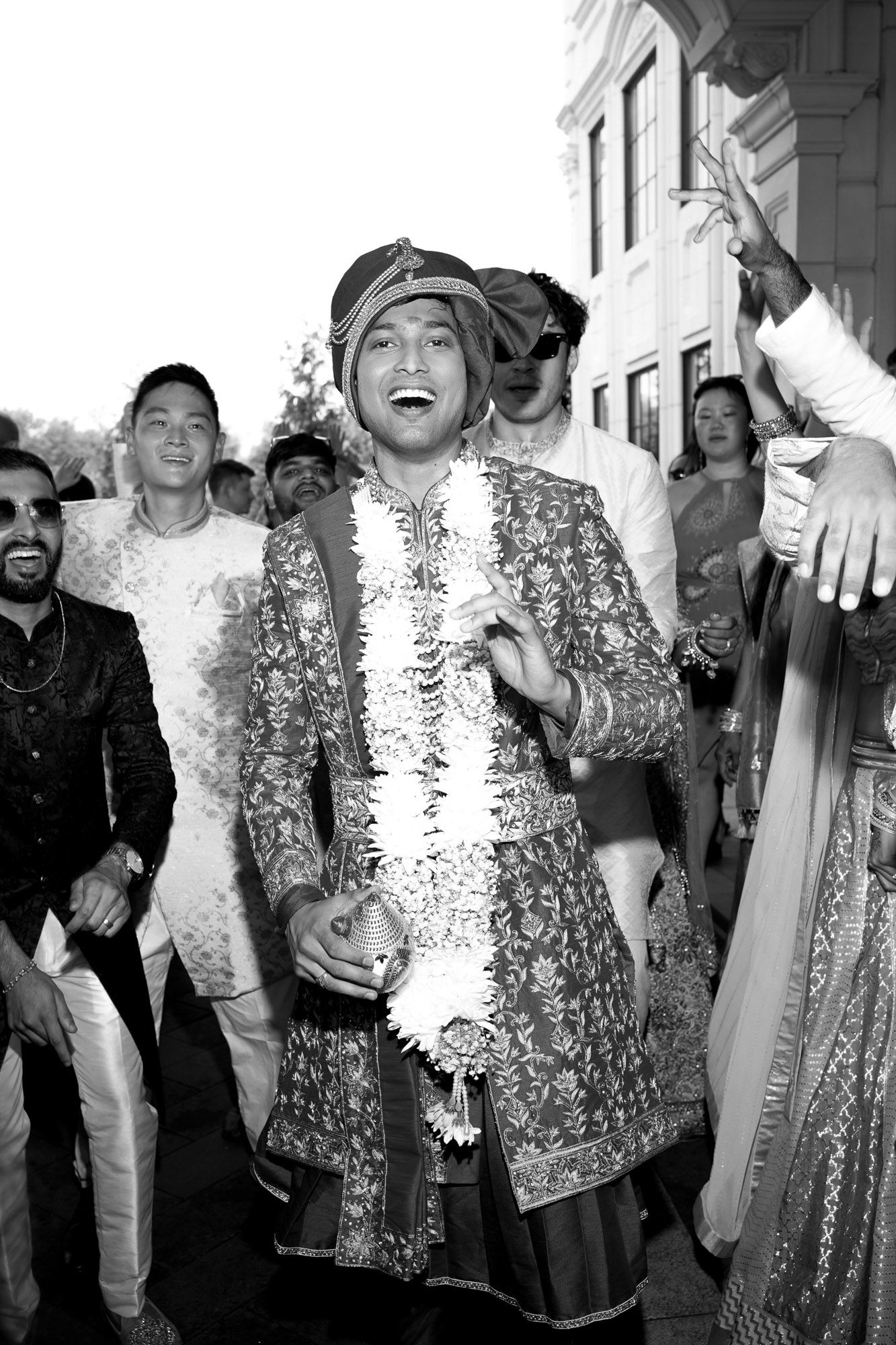 Group celebrating at an event wearing sparkly sequined outfits in black and white photography.