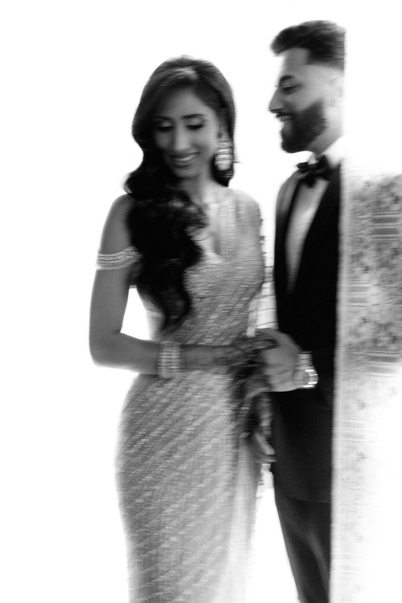 A couple in formal attire share intimate moments in a series of black and white artistic wedding photographs.