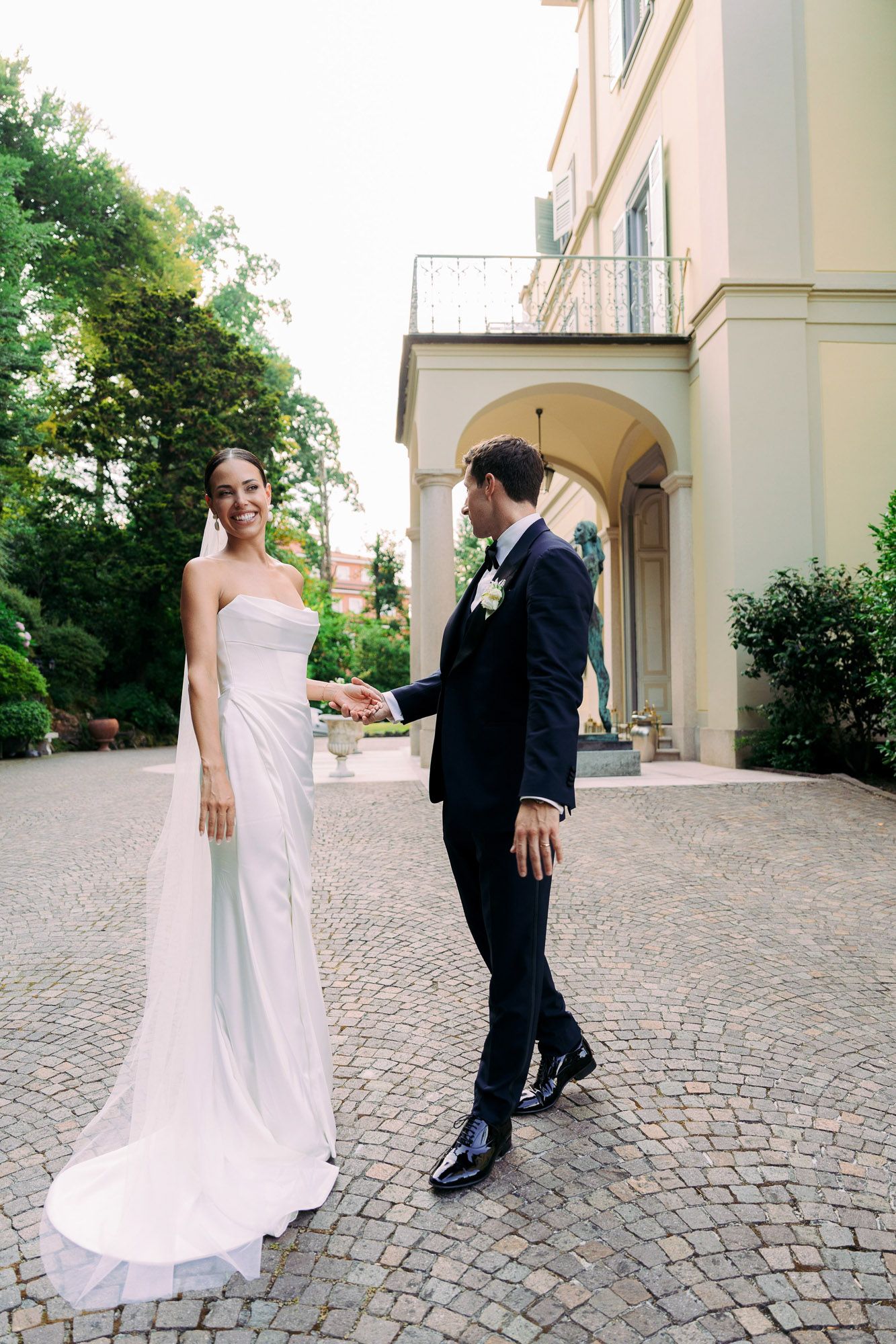 Sequence of outdoor wedding photos showing a couple dancing on a cobblestone courtyard.