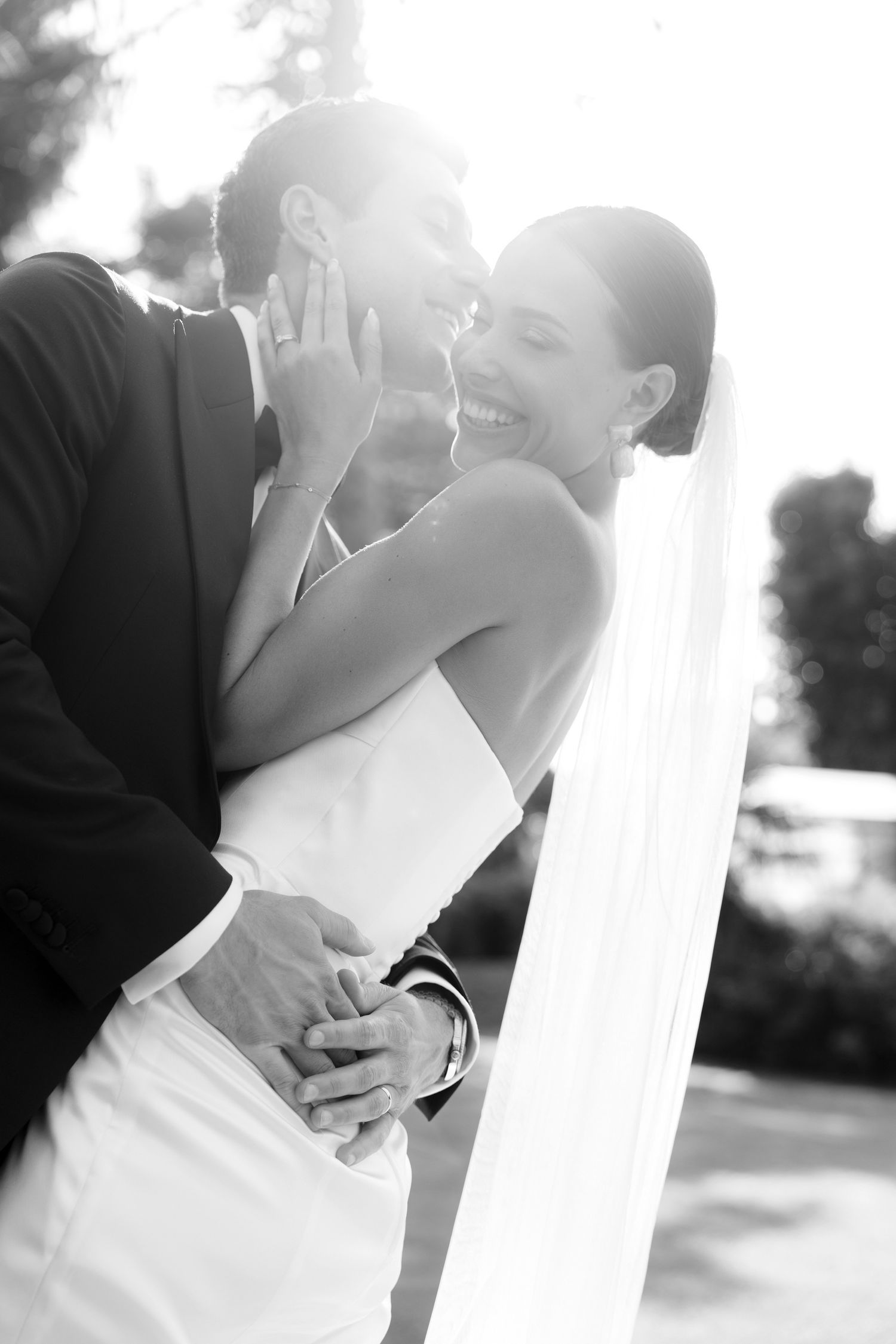 A romantic black and white photo series of a couple sharing intimate kisses during their wedding day.