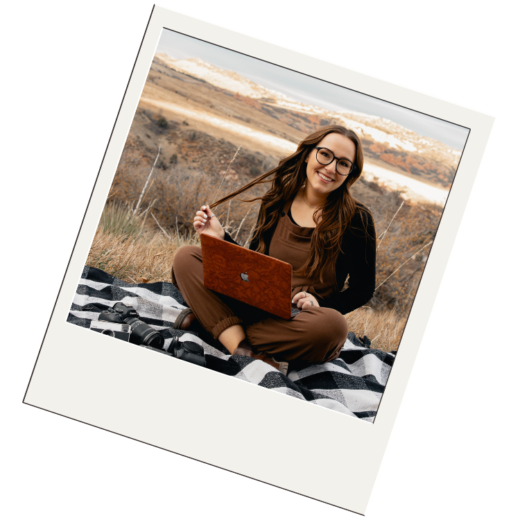 Someone sits on a blanket outdoors wearing brown overalls and glasses while enjoying a sunny autumn day in nature.