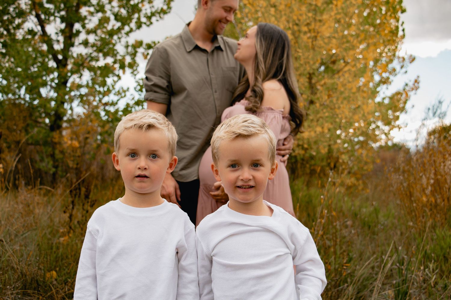 A family shares joyful moments together in a fall setting with golden leaves in the background.