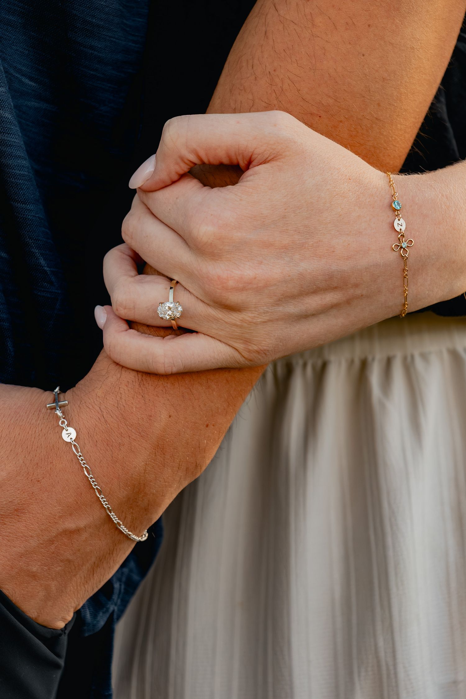 Close-up views of delicate gold bracelets and jewelry pieces worn on wrists against a dress background.