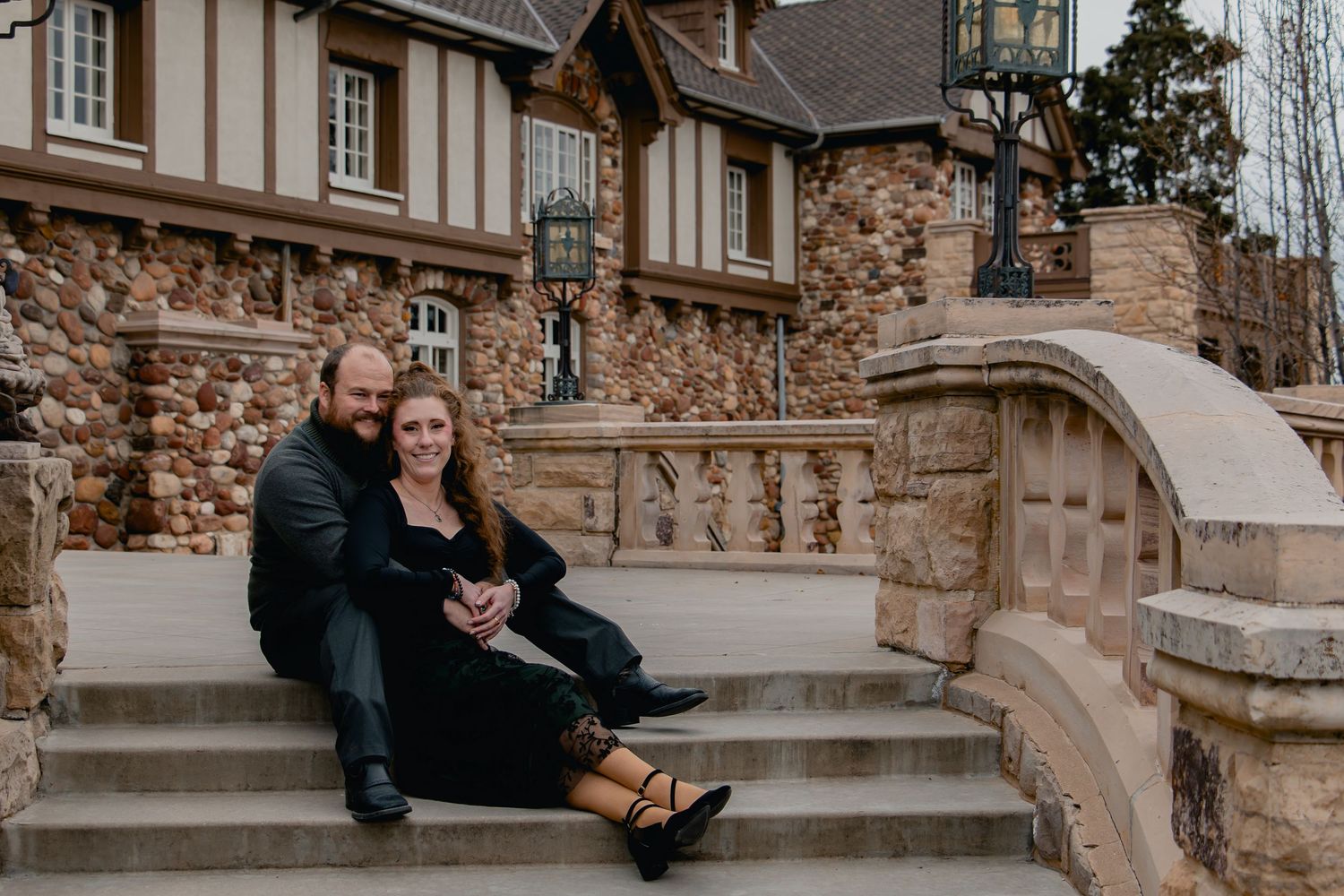 A series of five connected photos showing a couple sitting on stone steps in romantic poses at sunset.