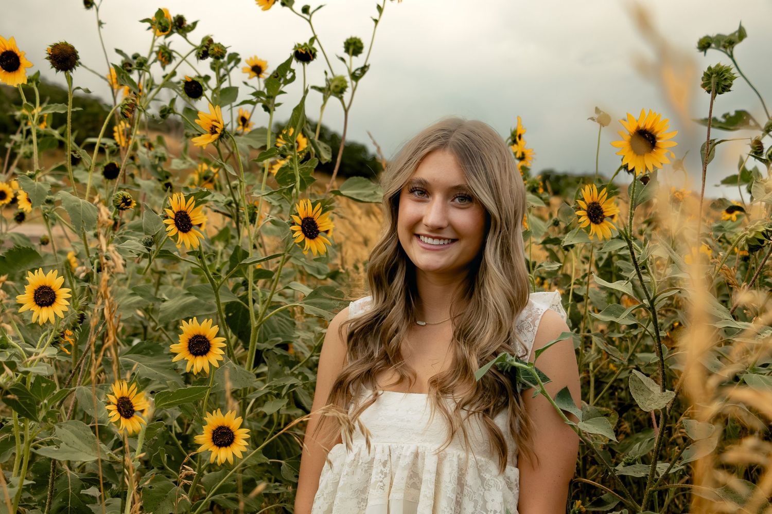 Cheerful figure stands in a vibrant yellow sunflower field during golden hour.