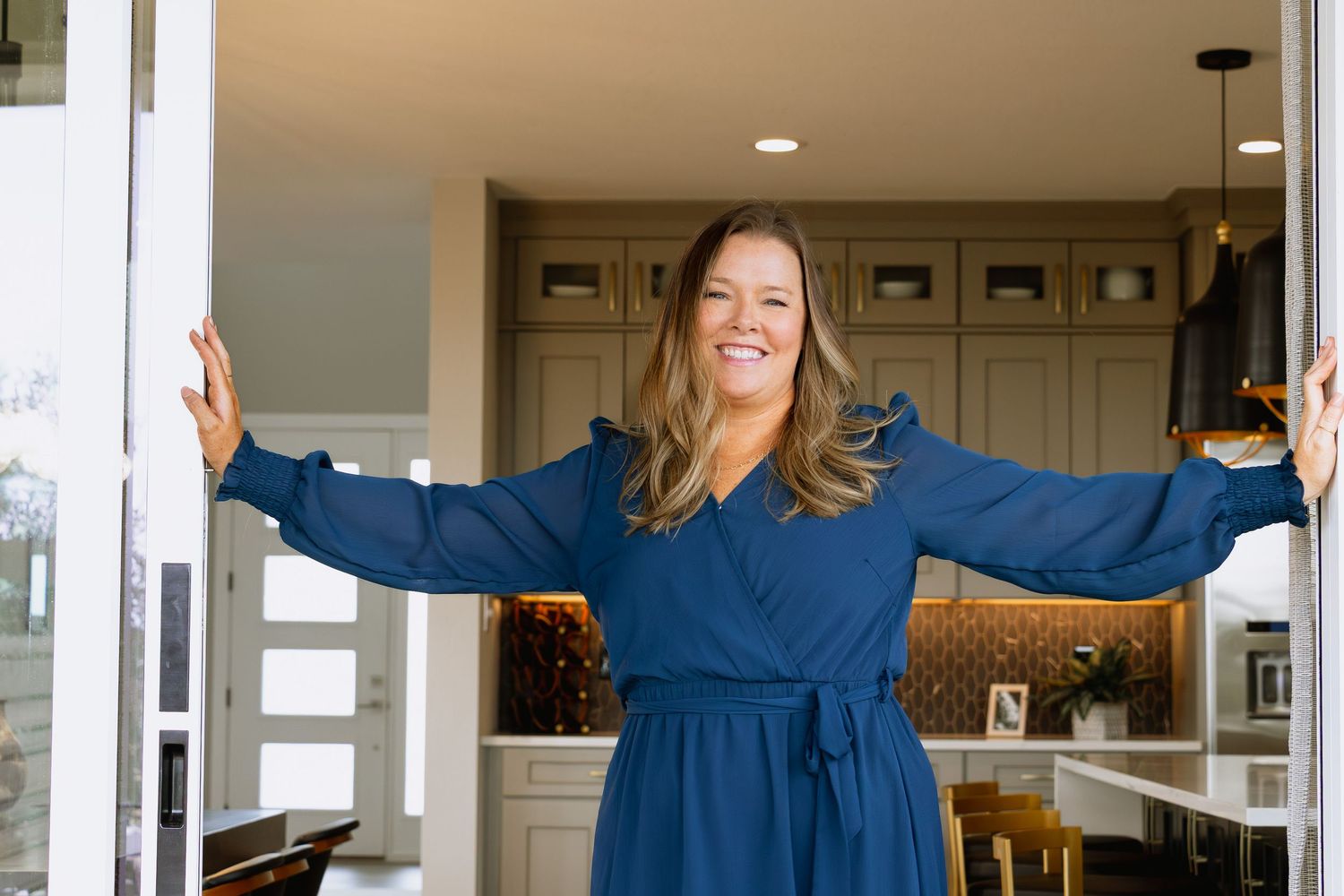 A sequence of a woman in a blue dress spinning and twisting with her arms outstretched in a bright interior setting.