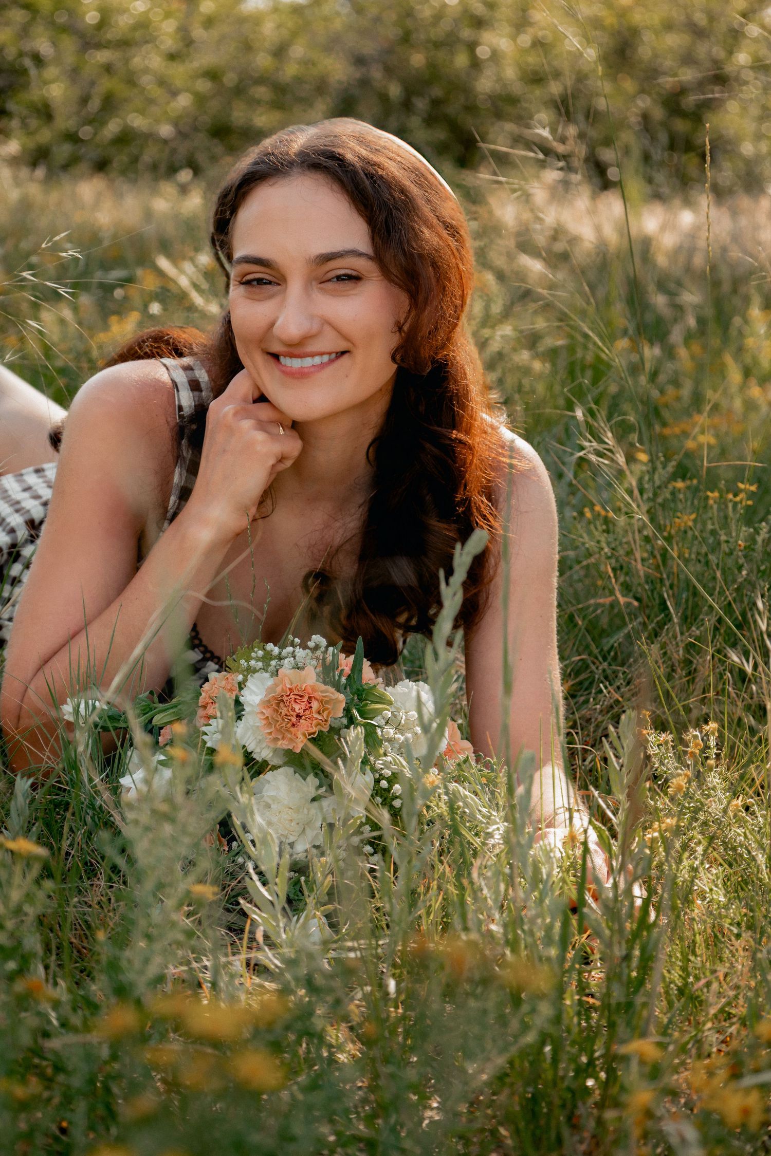 Five connected photos show someone lying in a wildflower meadow during golden hour sunlight.