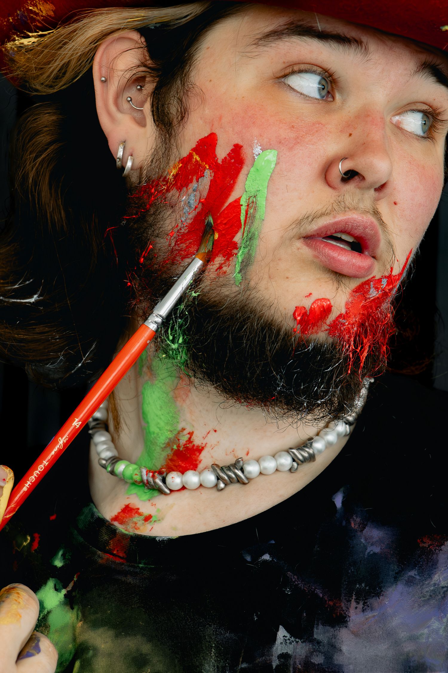 Creative portrait series showing paint splatter effects in red and green against dark background.