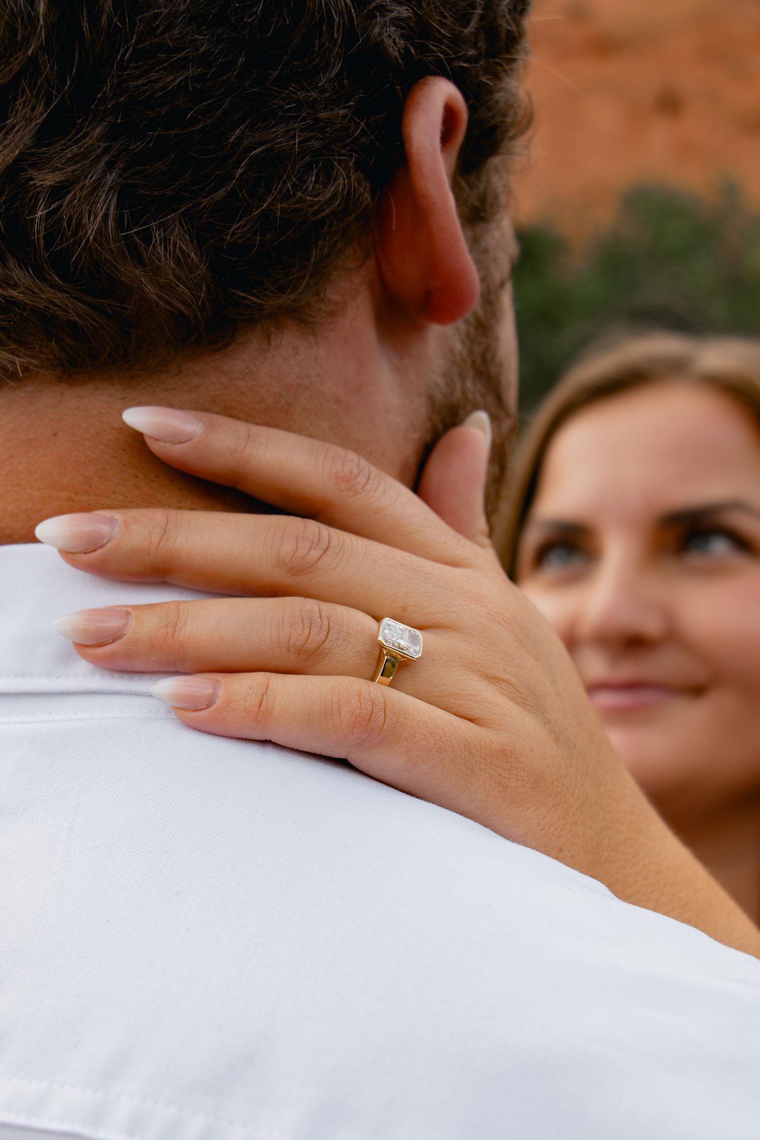A close-up series of photos showing a hand with an engagement ring resting on a white-clothed shoulder.