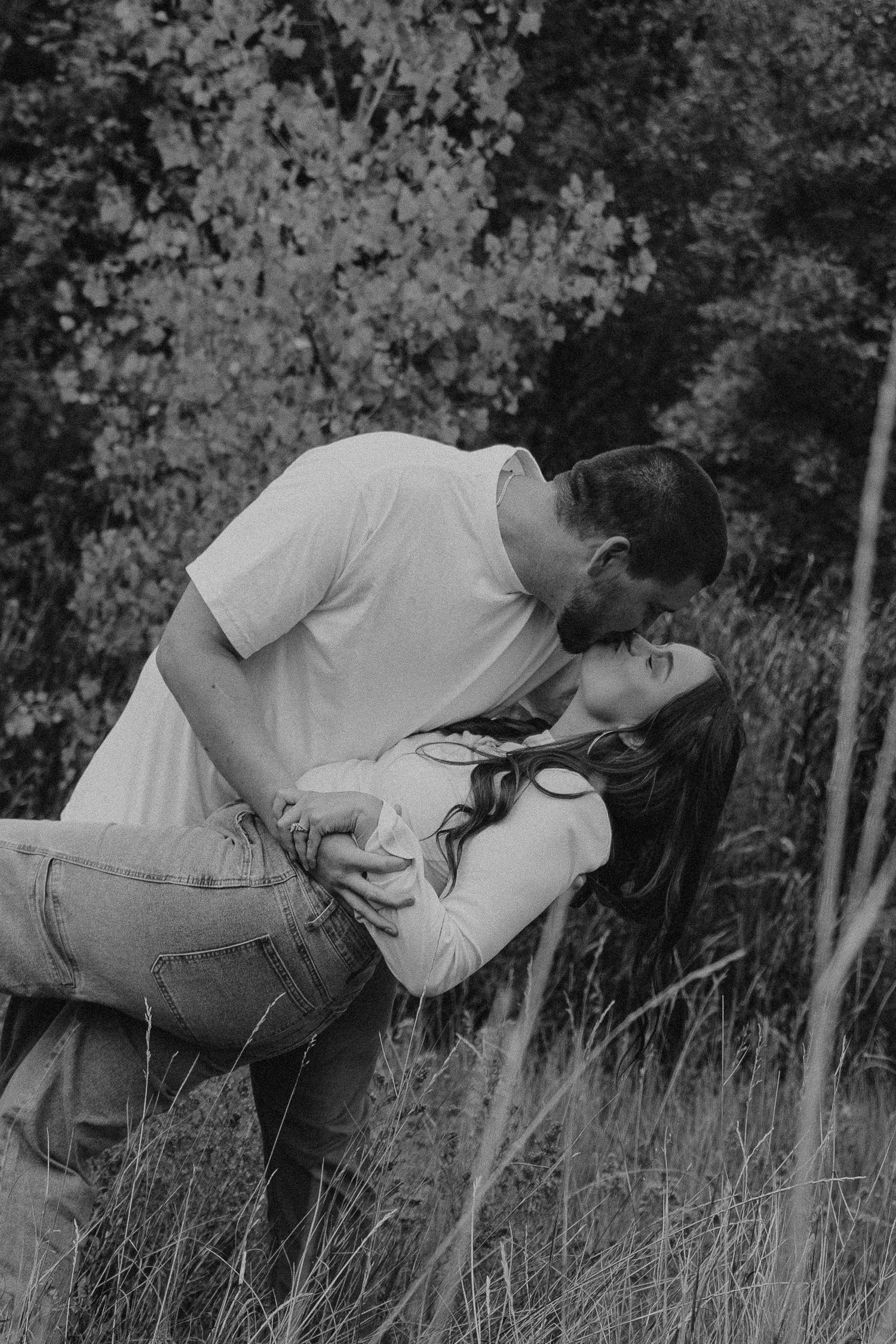Black and white photo sequence showing someone falling backwards into tall grass in a natural outdoor setting.
