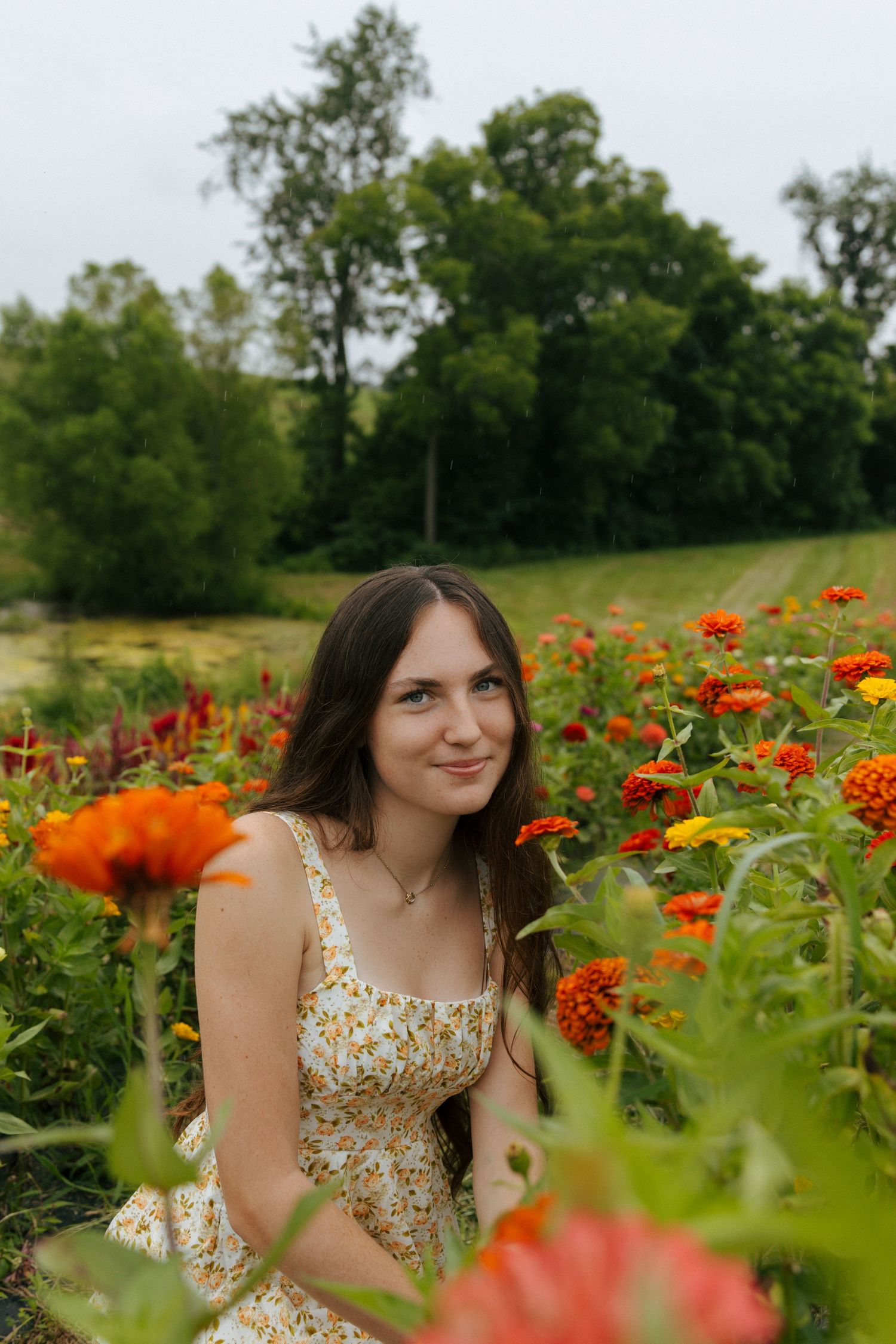 Dreamy portrait among vibrant orange flowers in a lush garden setting.