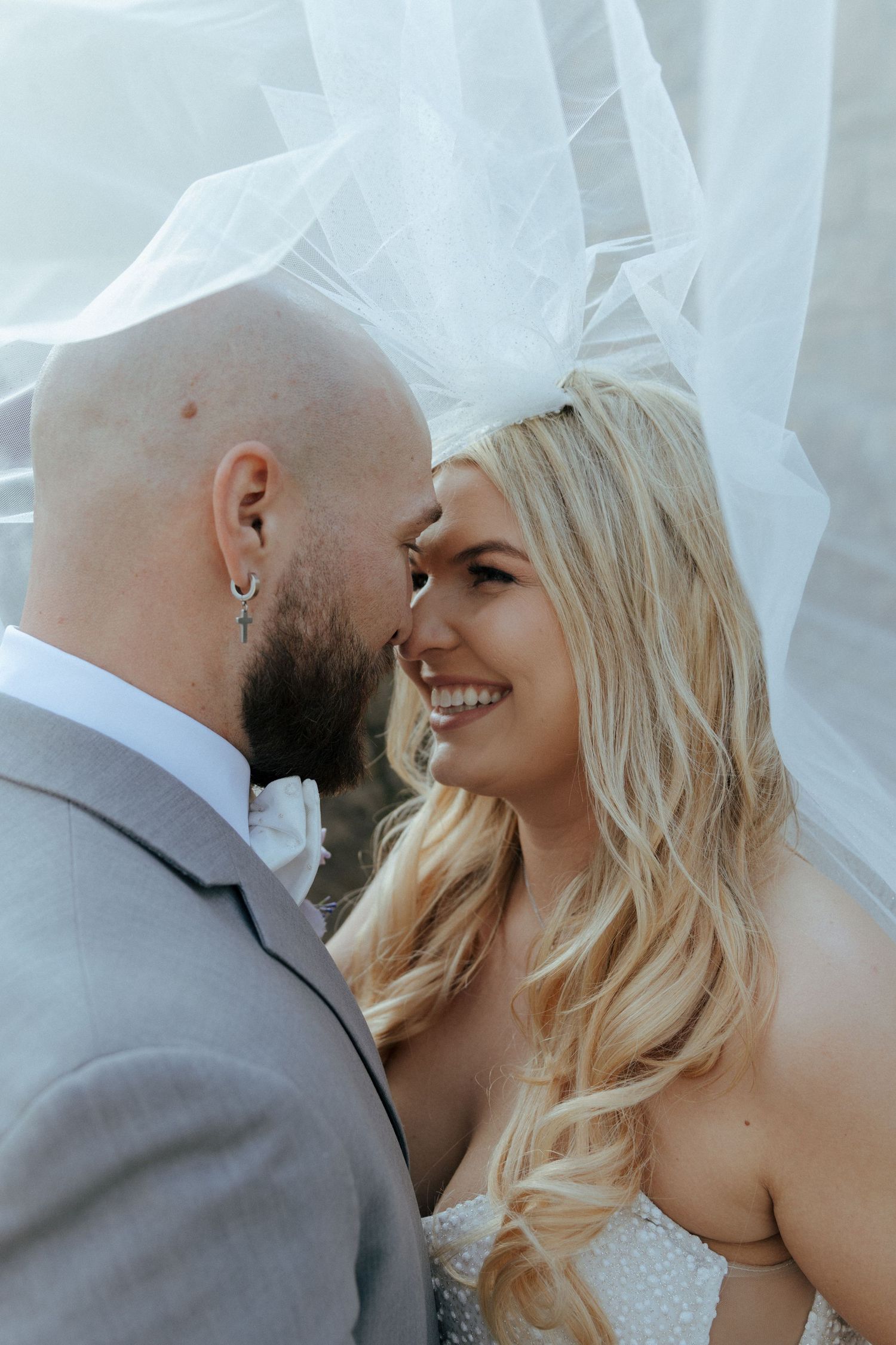 A romantic wedding photo sequence showing tender moments between a couple under flowing white veil.