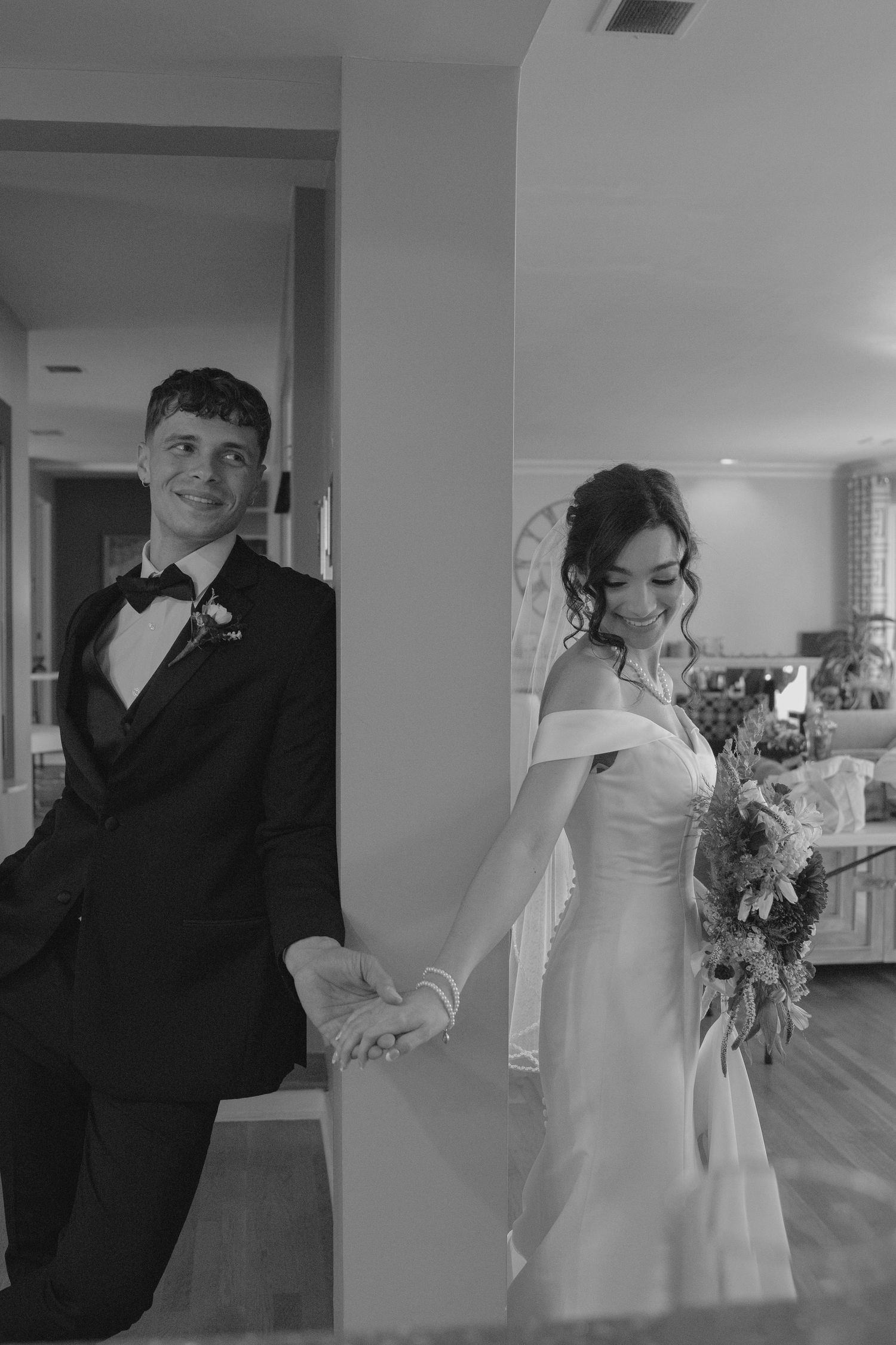 A couple in black and white formal attire dance together in an elegant indoor setting.