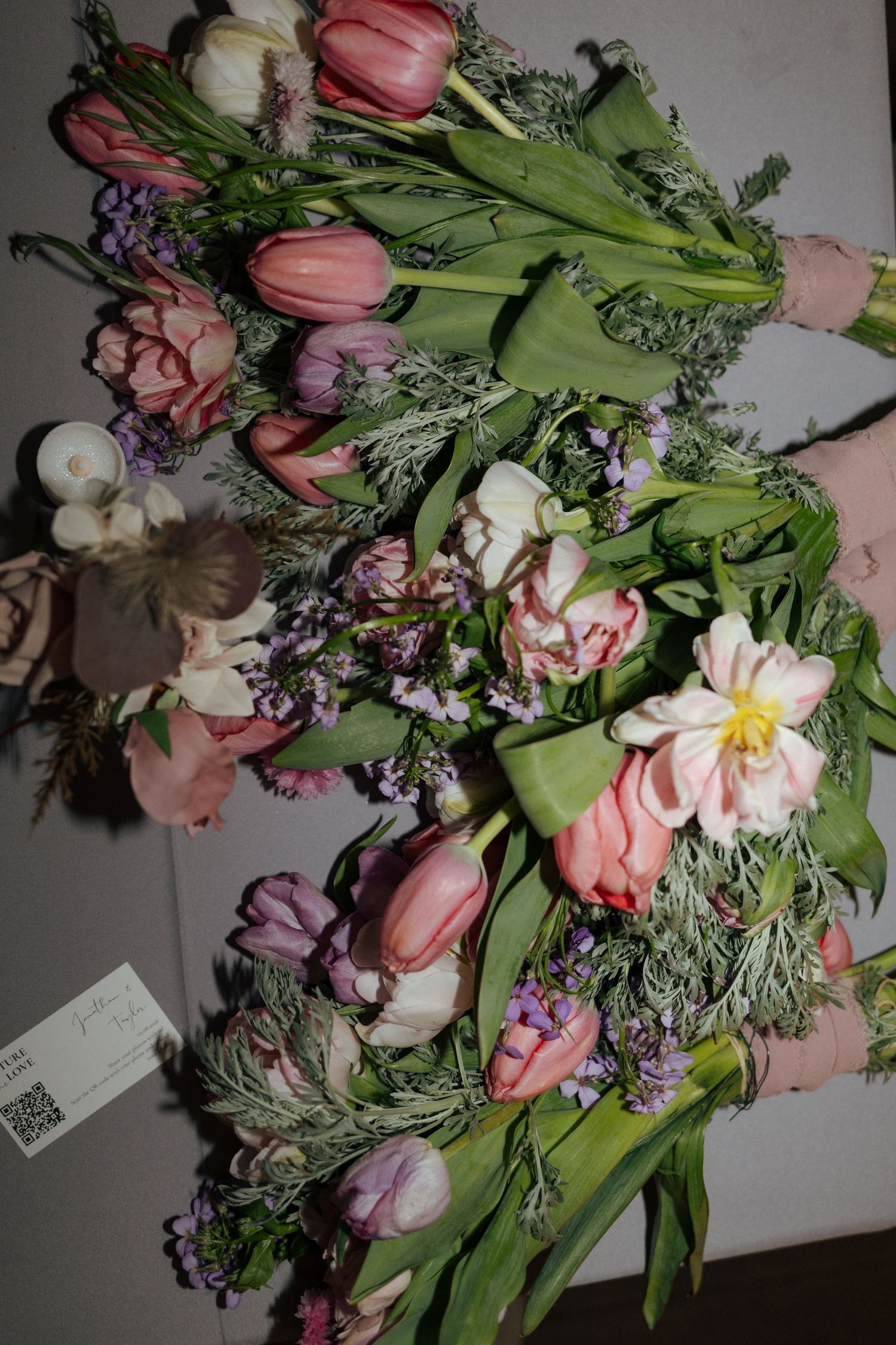 Two lush bouquets of pink tulips, purple wildflowers, and white blooms with green foliage arranged together.