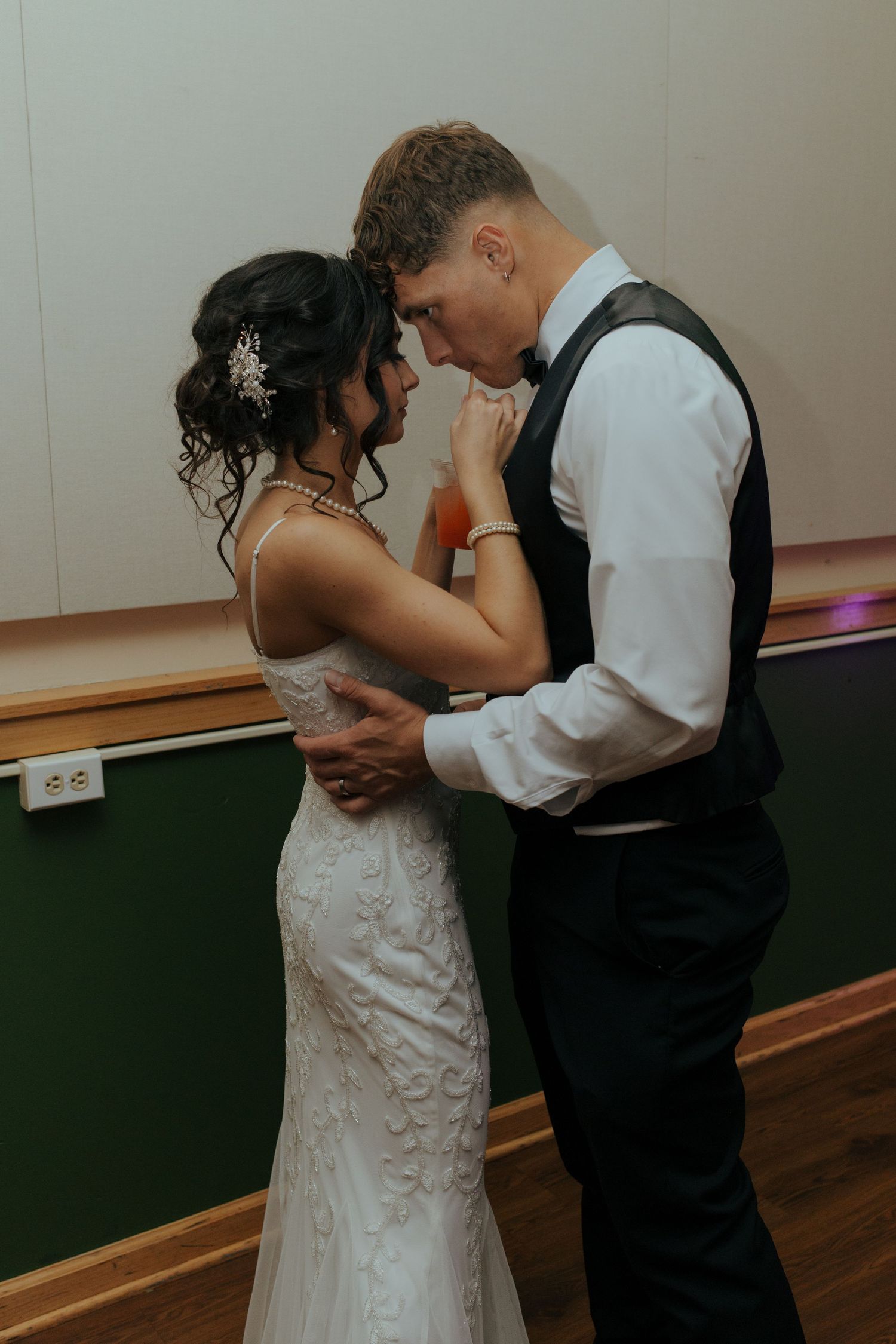 Bride and groom share intimate first dance in wedding reception venue.