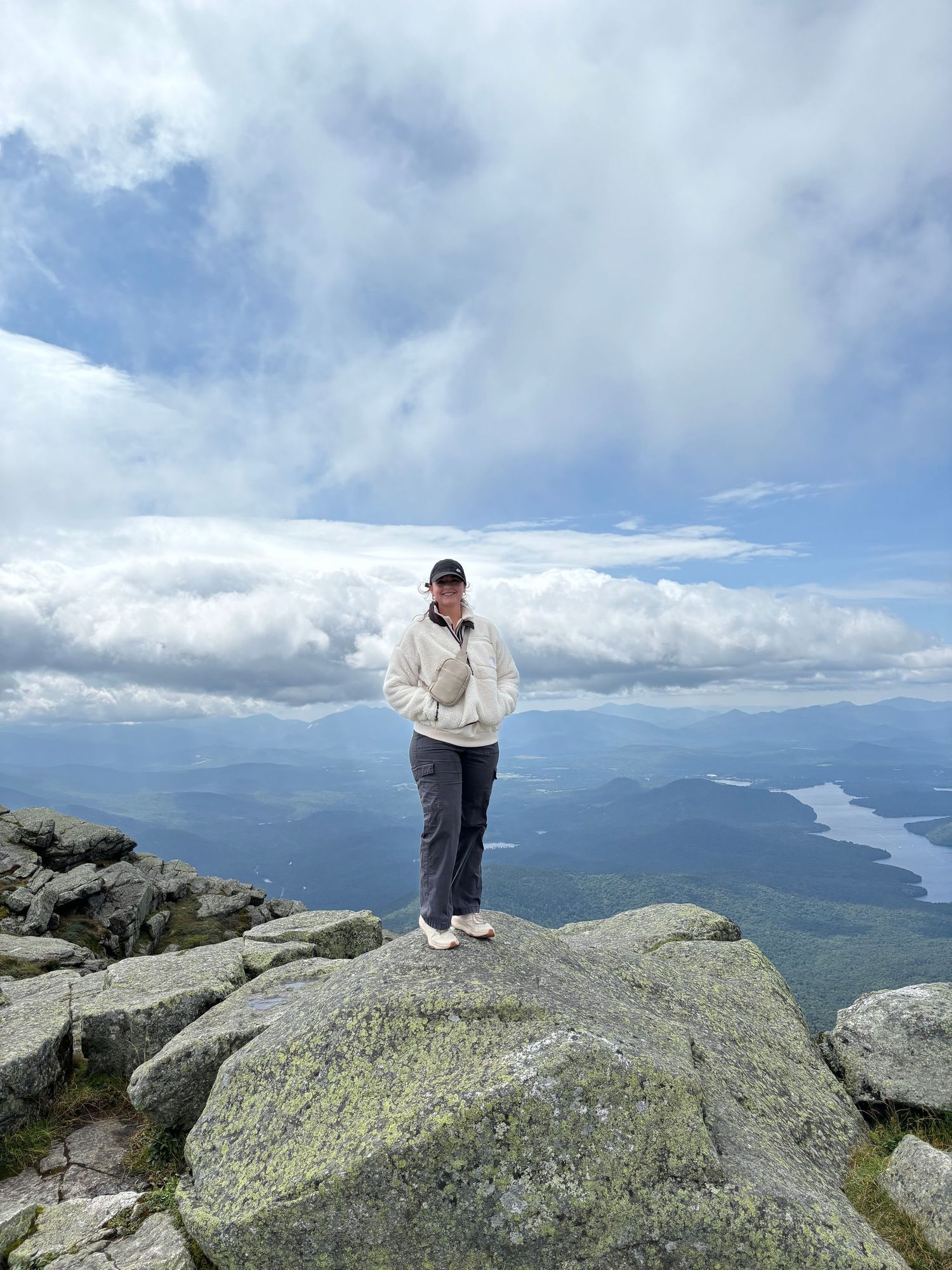 Scenic mountain landscape view from rocky summit overlooking lake and valleys below.