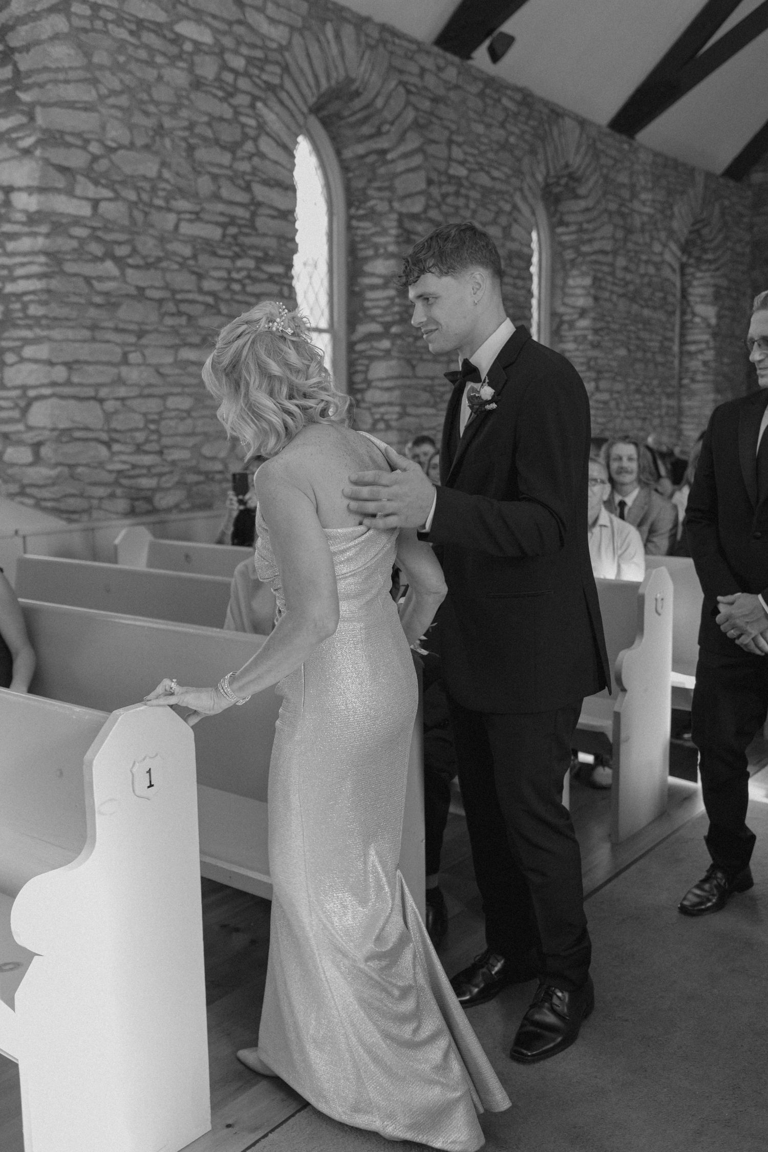 Bride and groom share an intimate moment at the altar inside a rustic stone church during their wedding ceremony.