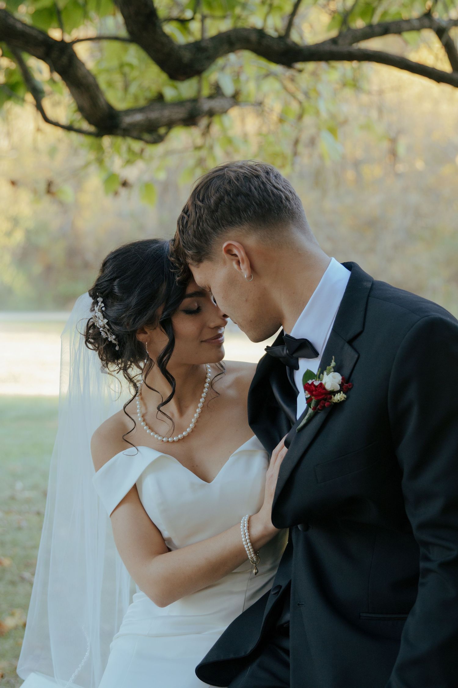A romantic wedding photo sequence captures tender moments between newlyweds under tree branches.