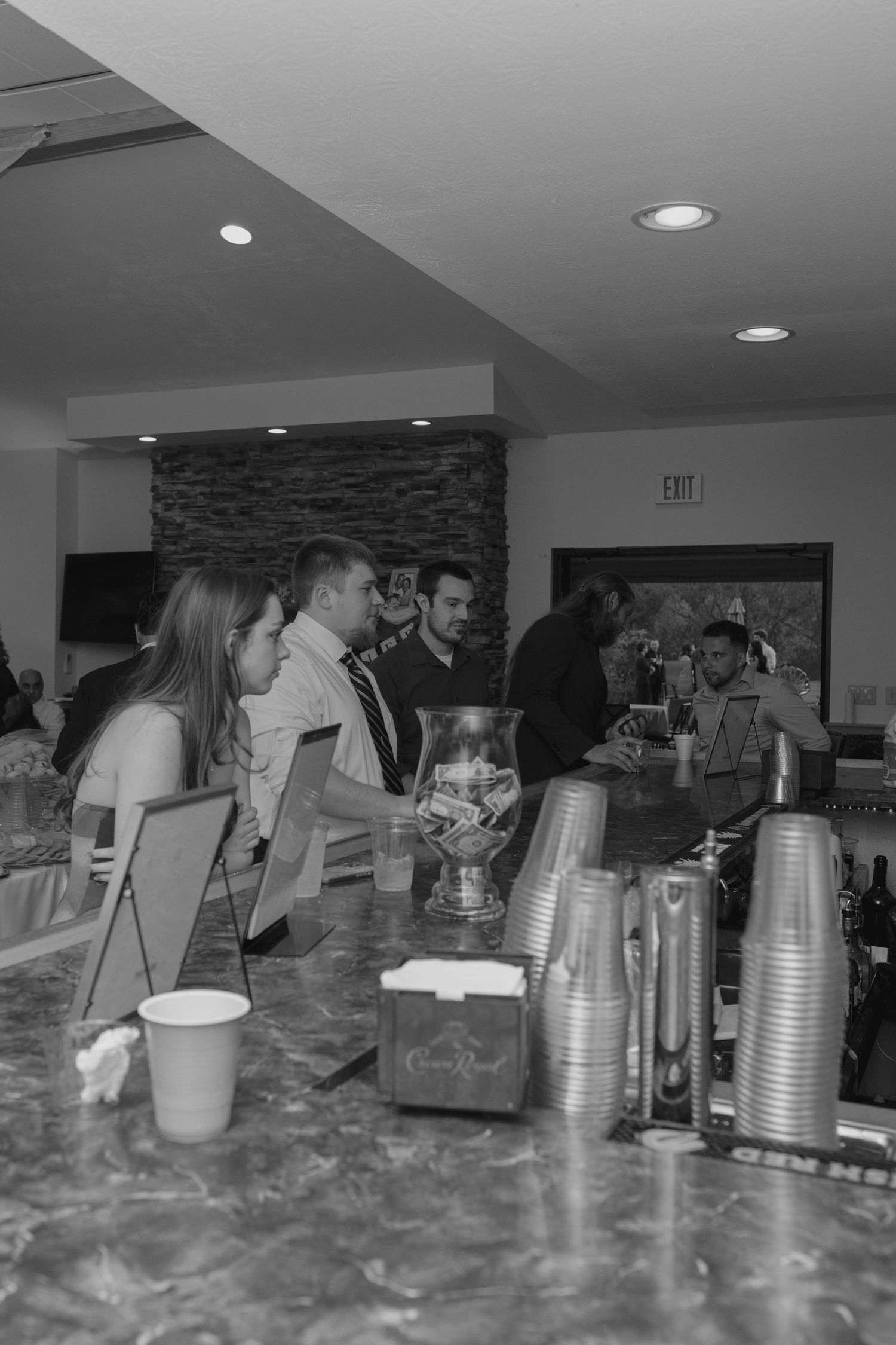 Wedding guests gather at bar with Crown Royal display.