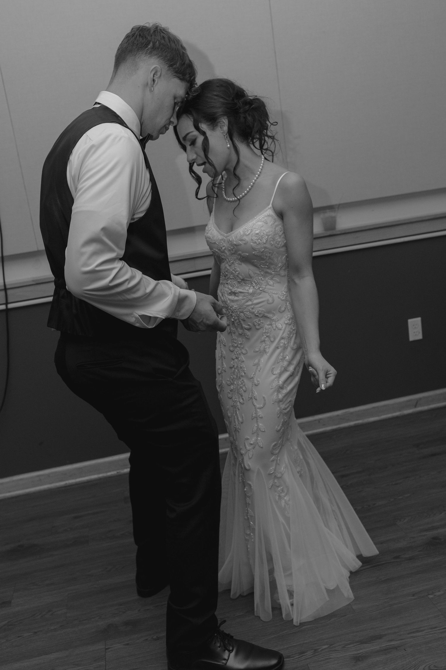 Black and white photo of bride and groom sharing an intimate first dance at their wedding reception.